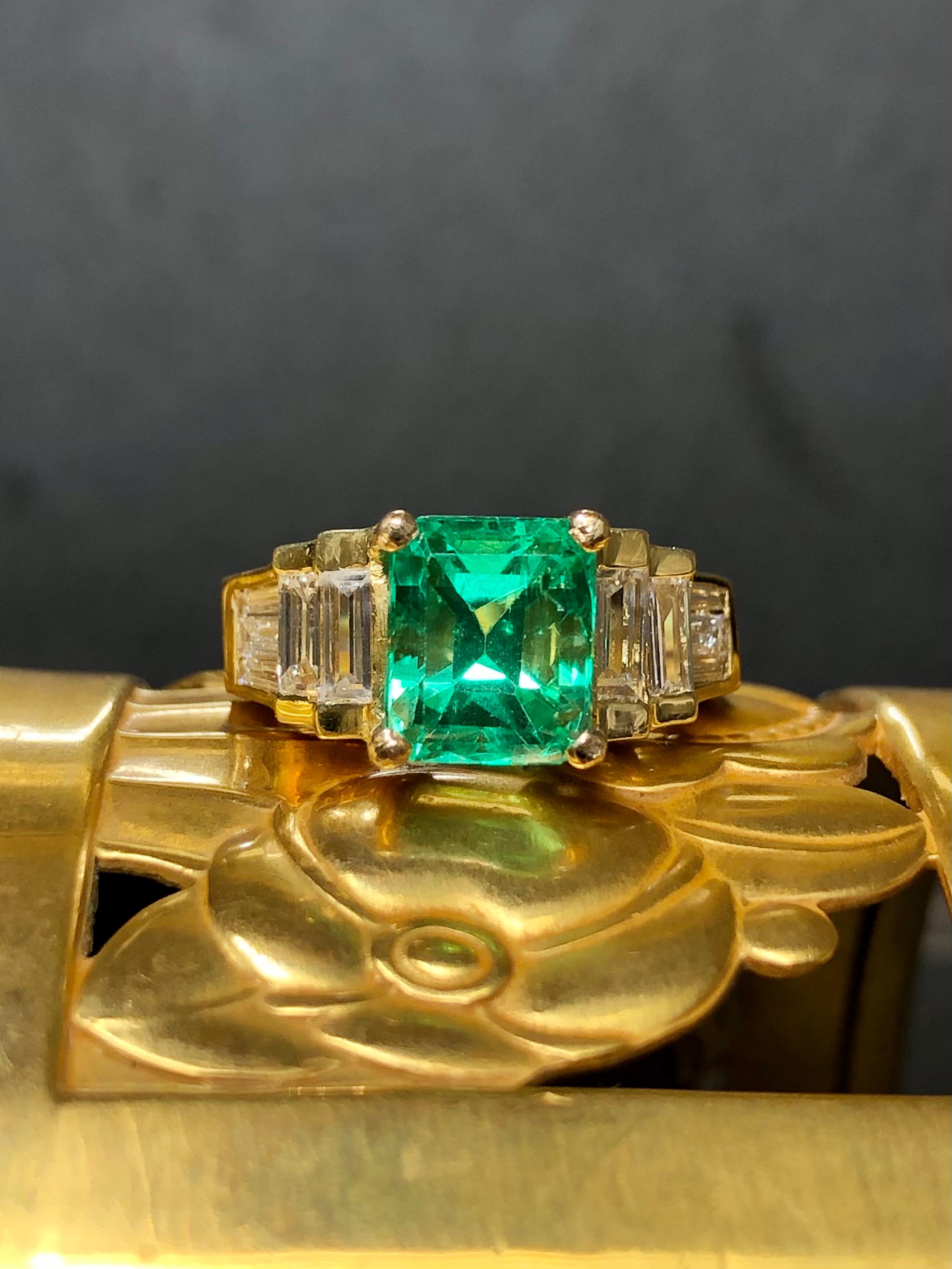 An impressive 2.62ct EYE CLEAN and minty color Colombian emerald set in a classic 18K yellow gold baguette diamond mount. The center stone has been inspected by GIA and has a Colombian origin and an F1 clarity rating. The material is gorgeous and