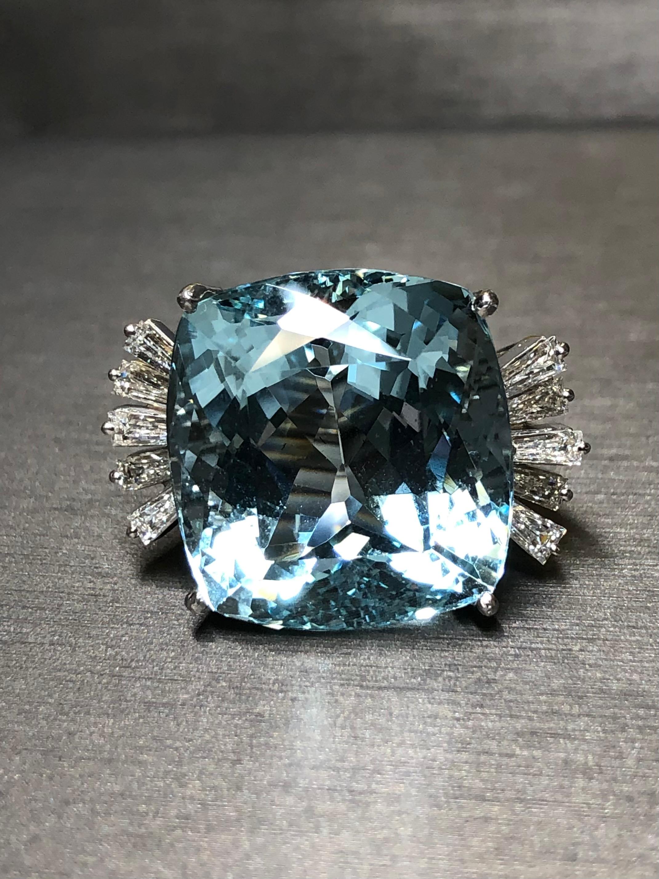 
A large, magnificent cocktail ring c. early 1960’s hand done in 18K white gold and centered by a 45ct (weighed) gorgeous cushion cut aquamarine exhibiting a bright and lively color without being dark and oversaturated. The crystal has been expertly