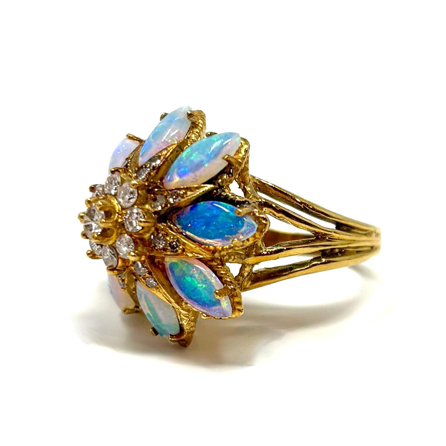 A Mid-Century black opal and diamond cocktail ring set in 18K gold. It contains approximately 2.64 carats of glowing black opals accented by approximately .72 carats of bright diamonds. 