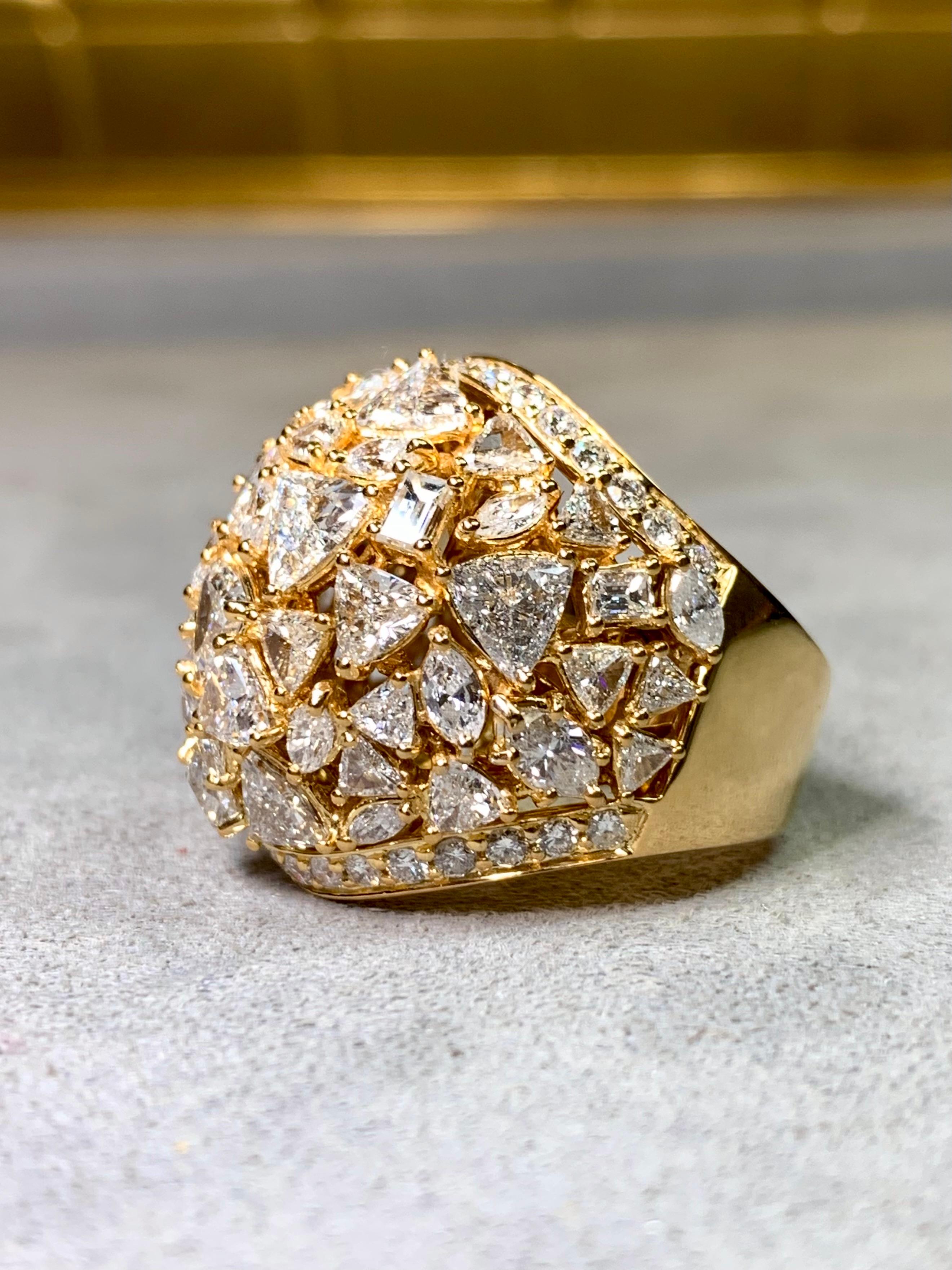 Un audaz y opulento anillo de cóctel estilo bombé, exquisitamente elaborado en oro amarillo de 18 quilates y totalmente incrustado con un deslumbrante mosaico de diamantes. El diseño presenta una ingeniosa mezcla de tallas marquesa, trillante,