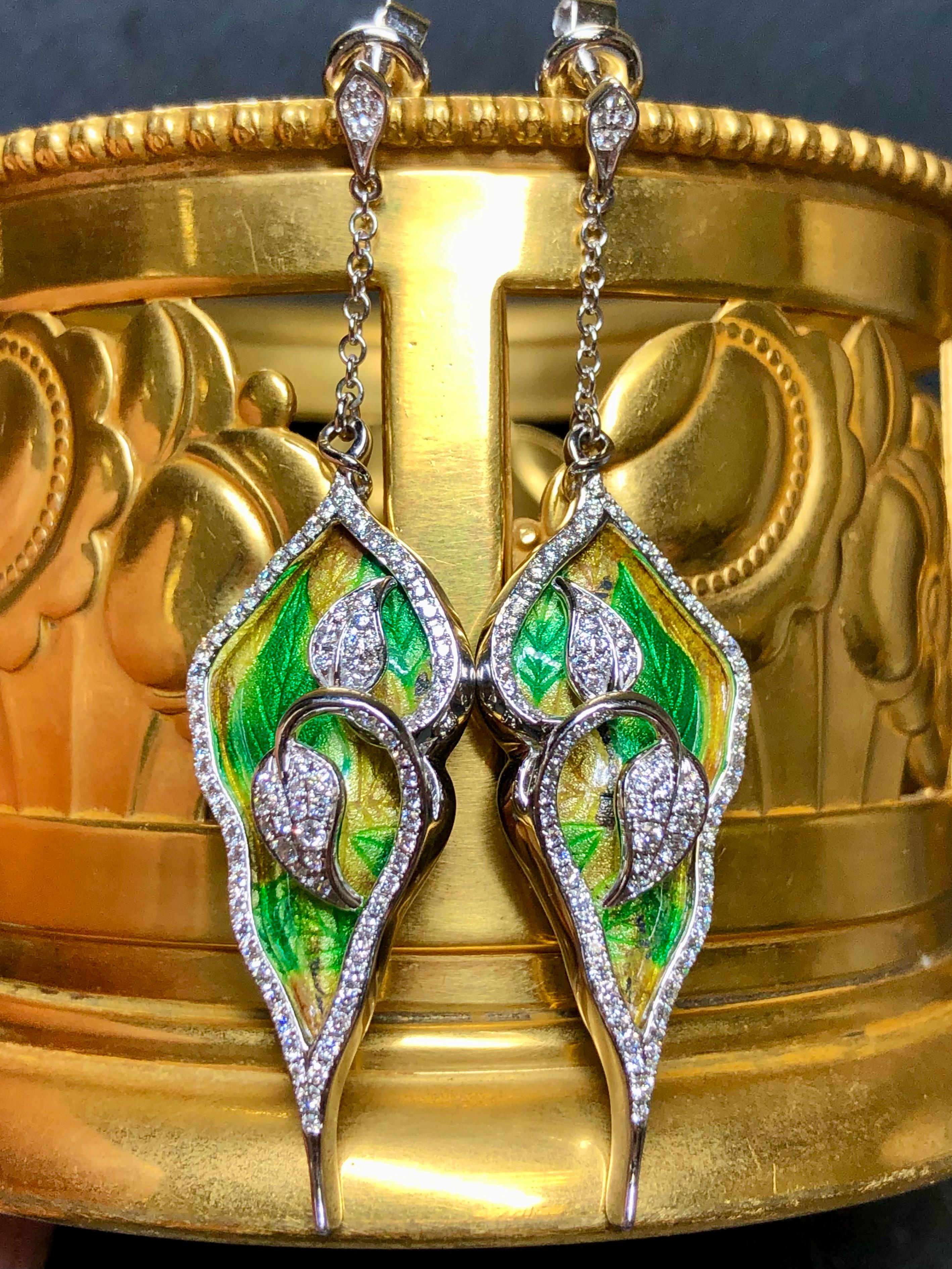 An elegant and whimsical pair of drops done in 18k white white and beautifully done inlaid green and yellow enamel. The earrings are framed with approximately 2cttw in G-H color Vs1-2 clarity round diamonds. These earrings have posts with friction