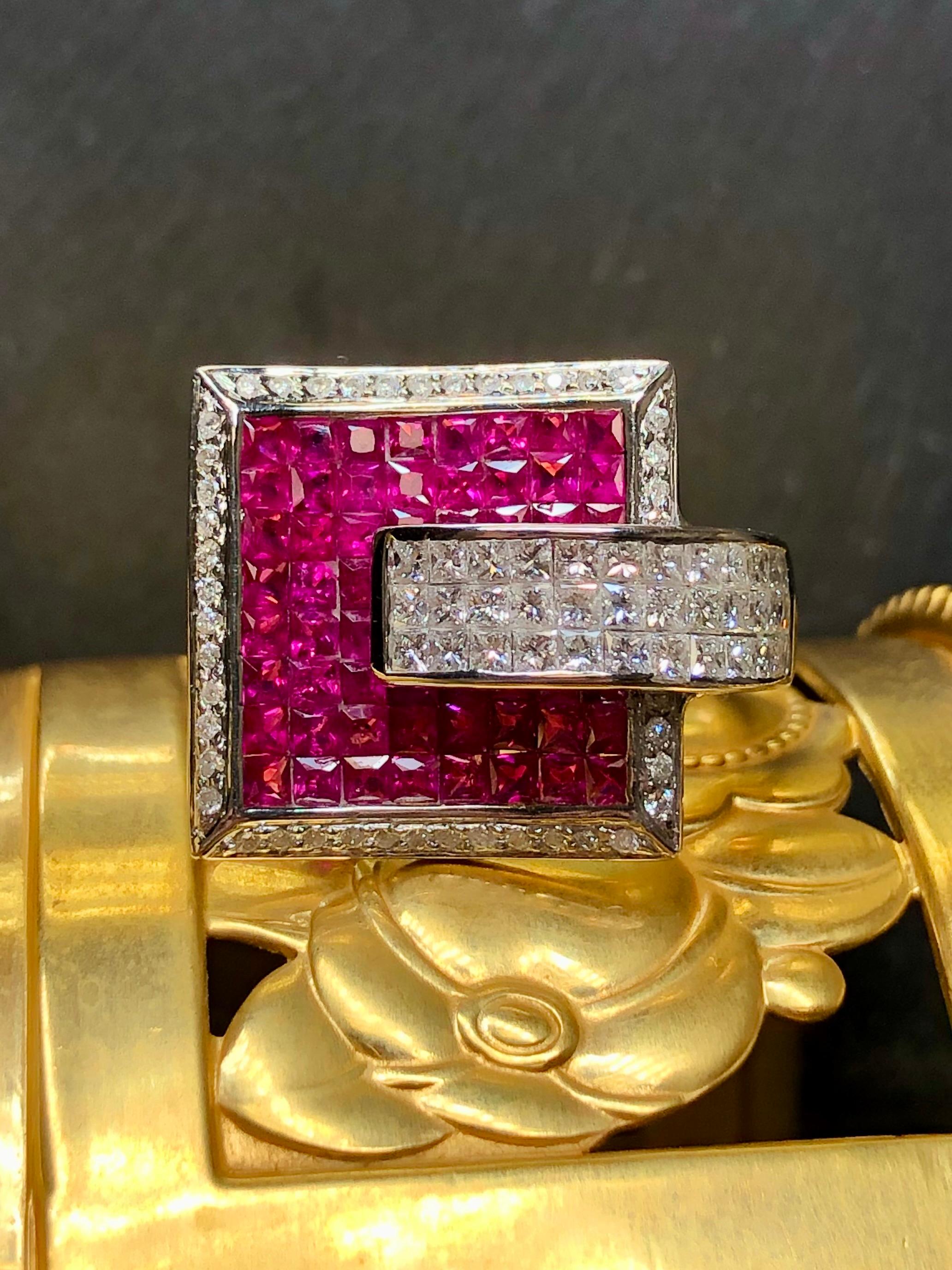 This bold cocktail ring is done in 18K white gold and invisibly set with approximately 5.60cttw in vibrant natural red rubies as well as 2.24cttw in G-I color Vs2-Si1 clarity princess cut diamonds. A beautiful design with great attention to detail