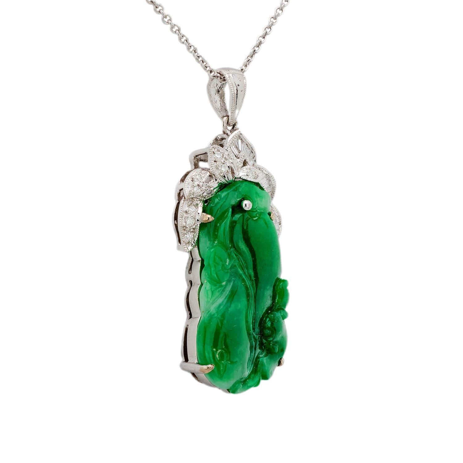 A fabulous diamond and jade pendant necklace! Crafted in 18k white gold, this necklace features an oblong piece of carved jade, which is decorated with a swirling-floral motif. The jade is held within a five-prong setting and displays a magnificent