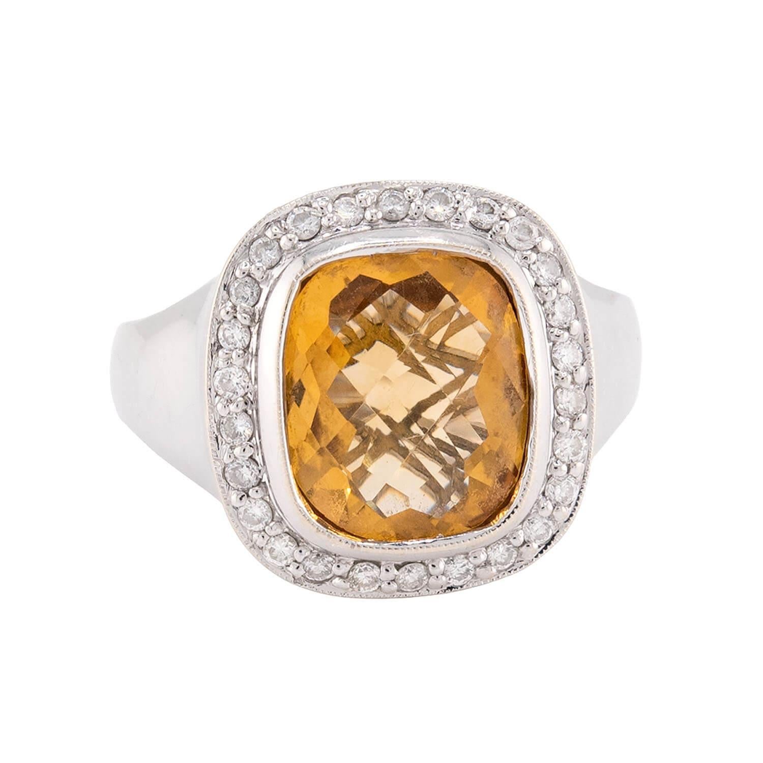 Un anello audace e colorato! Realizzato in oro giallo e bianco 18 carati, questo anello presenta una pietra citrina Madeira incastonata, meravigliosamente sfaccettata e dalla vibrante tonalità arancione. La pietra citrina è circondata da un'aureola