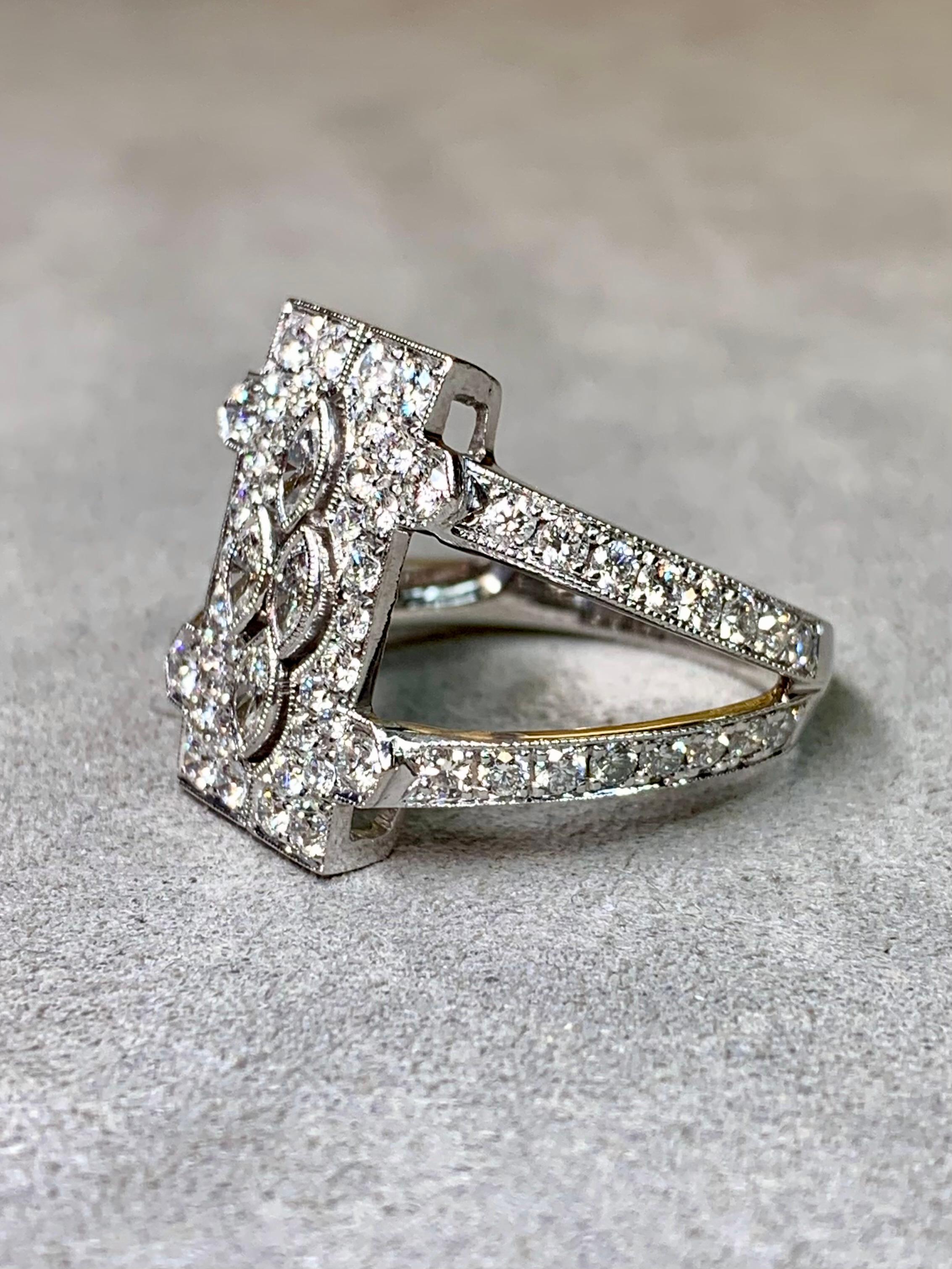 An exceptionally well-made ring, handcrafted in 18K white gold and both bead and bezel set with perfectly matched E-G color Vs1+ clarity round and larger marquise cut diamonds. It has a beautiful openwork design with great attention to detail in its