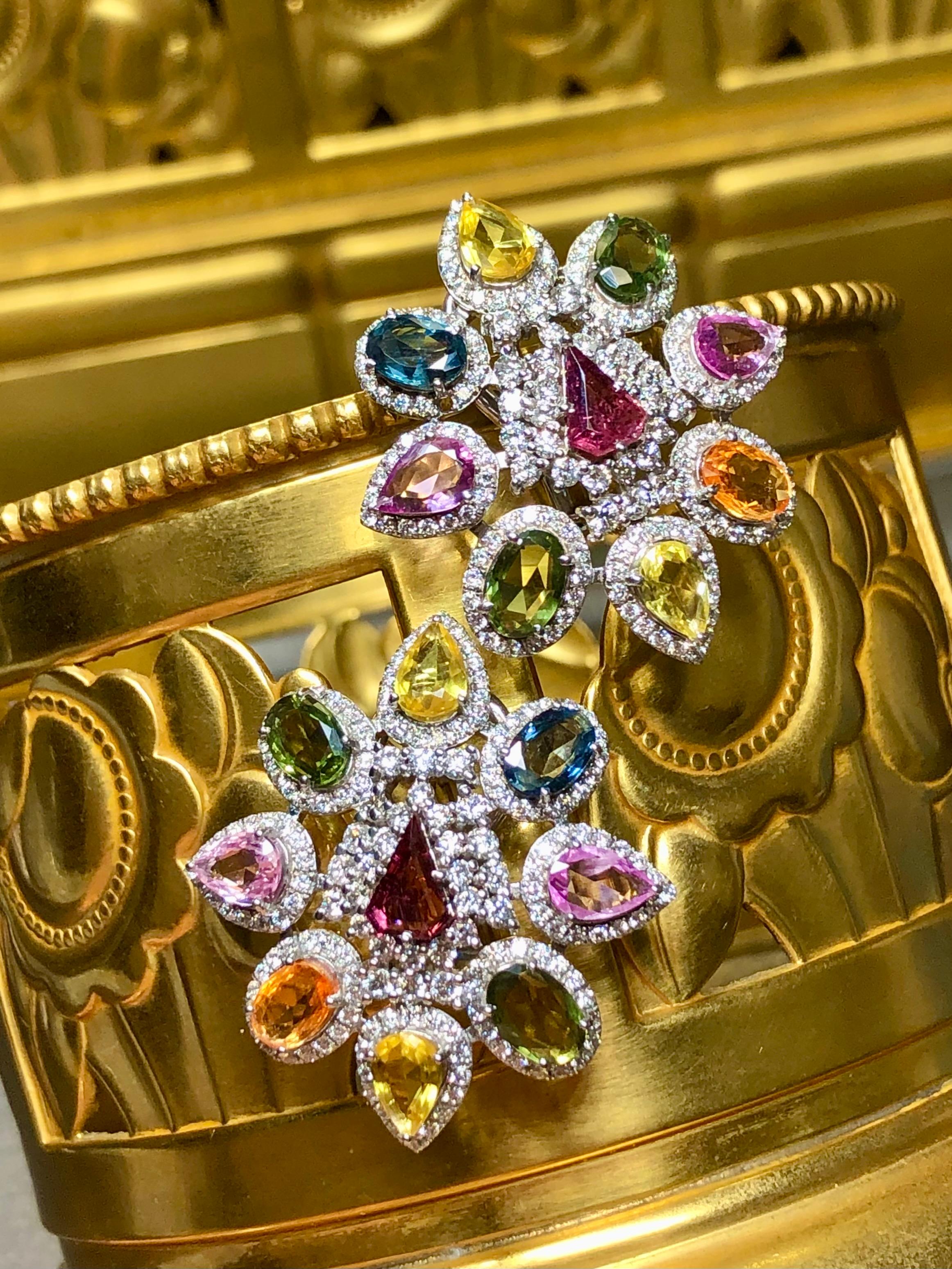 
Ein wunderschönes und lebhaftes Paar Ohrringe aus 18 Karat Weißgold, besetzt mit zahlreichen ausgefallen geformten, mehrfarbigen natürlichen Saphiren von insgesamt ca. 7,10cttw sowie ca. 3,90cttw runden Diamanten der Farbe H-I, Vs2-SI1. Die