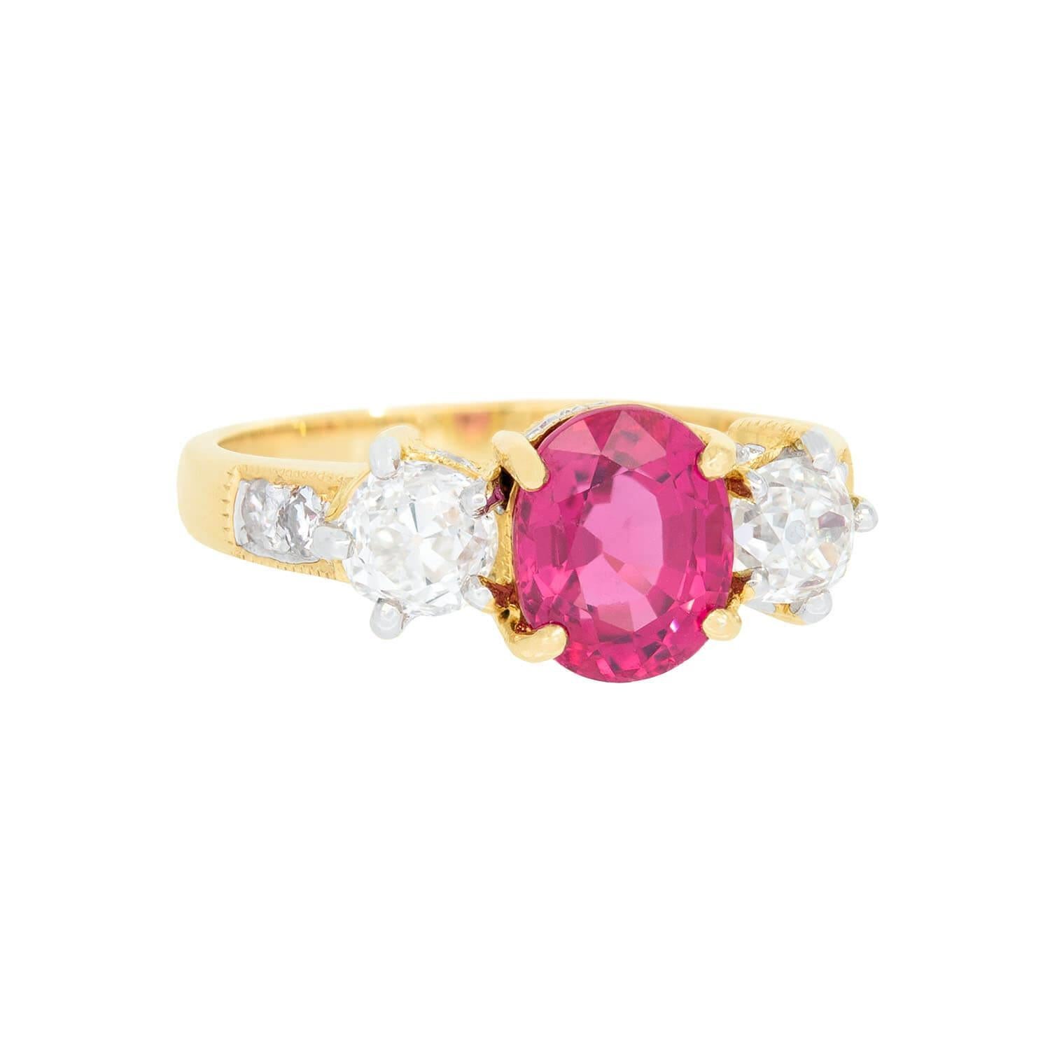 A beautiful Estate spinel and diamond ring! This gorgeous piece is crafted in 18k yellow gold and features a vivid oval cut 1.82ct spinel prong set at the center. The spinel displays an incredible reddish-pink hue. Framing the spinel are two prong