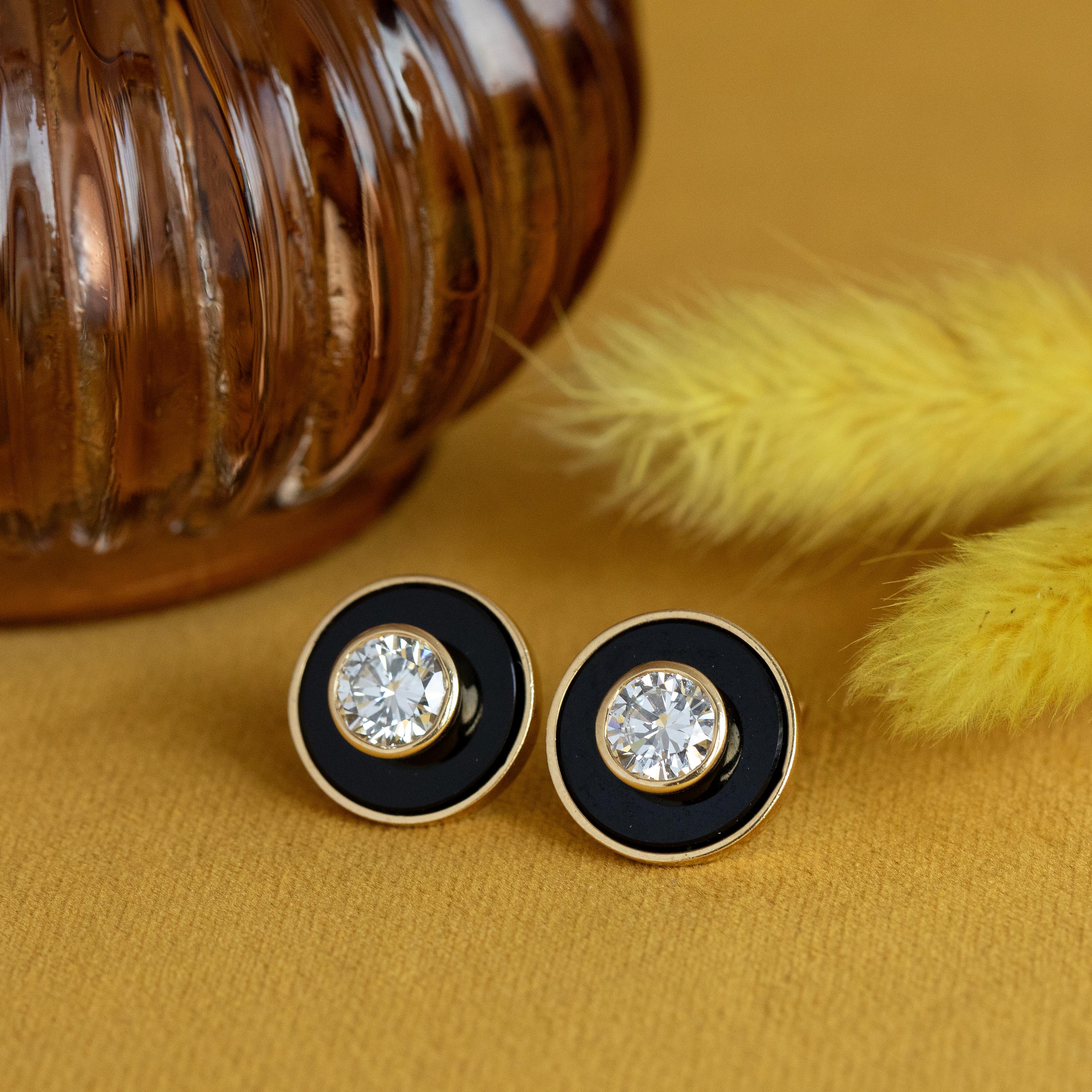 Exquisite stud earrings are crafted from rich and buttery 18K yellow gold, featuring onyx cabochon gemstones punctuated by sparkling, brilliant cut diamonds. J-K in color, these diamonds weigh an estimated 1.24 carats each, for a combined total