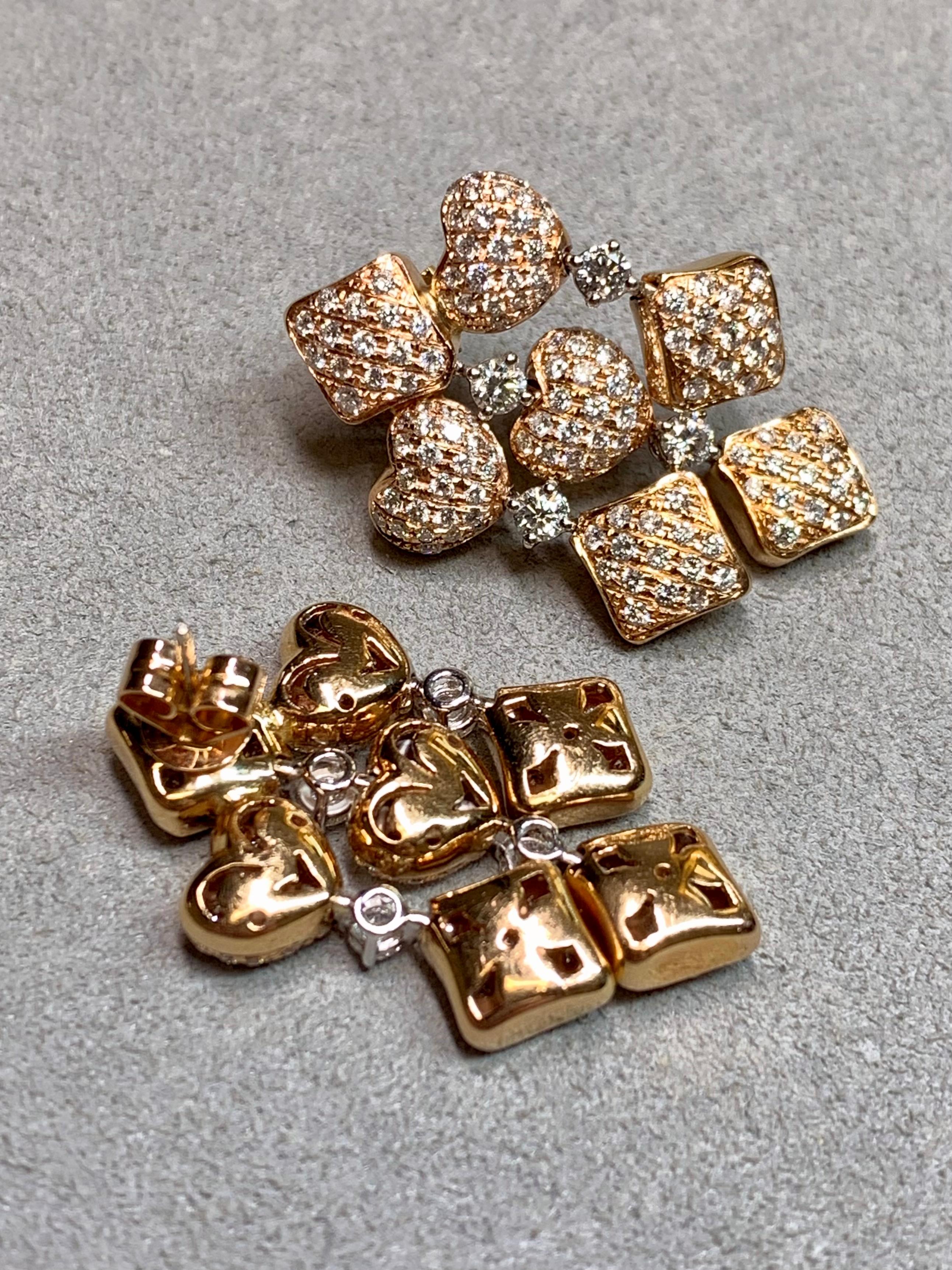 These beautifully constructed contemporary earrings are crafted in 18 karat yellow and white gold, designed with an elegant arrangement of puffed heart and diamond-shaped elements. Fully articulated, each diamond-set section moves fluidly with the