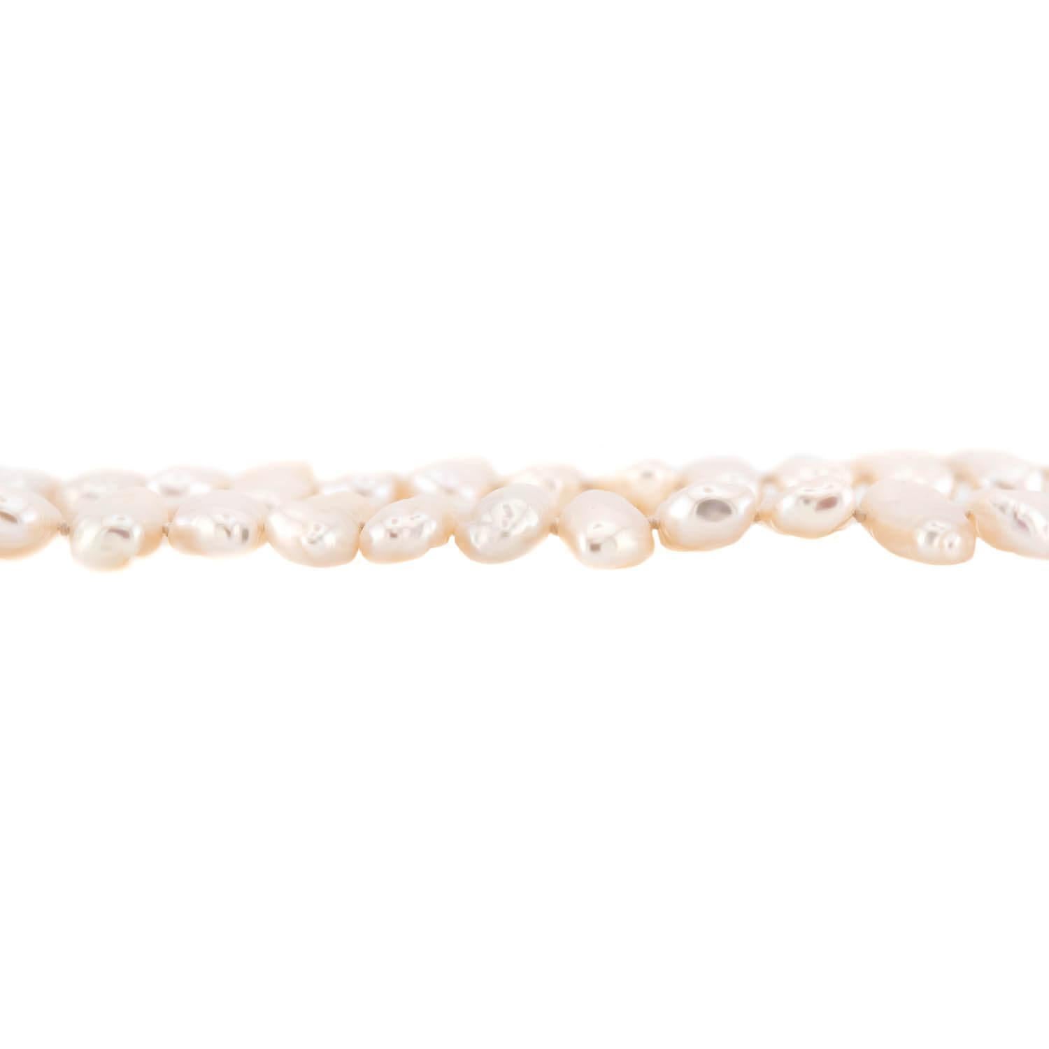 A feminine and unique pearl necklace! Crafted in 18k yellow gold, this necklace is composed of Biwa pearls, which are all individually knotted and strung on white thread. The pearls display a fabulous luster, and are quite eye-catching. The necklace