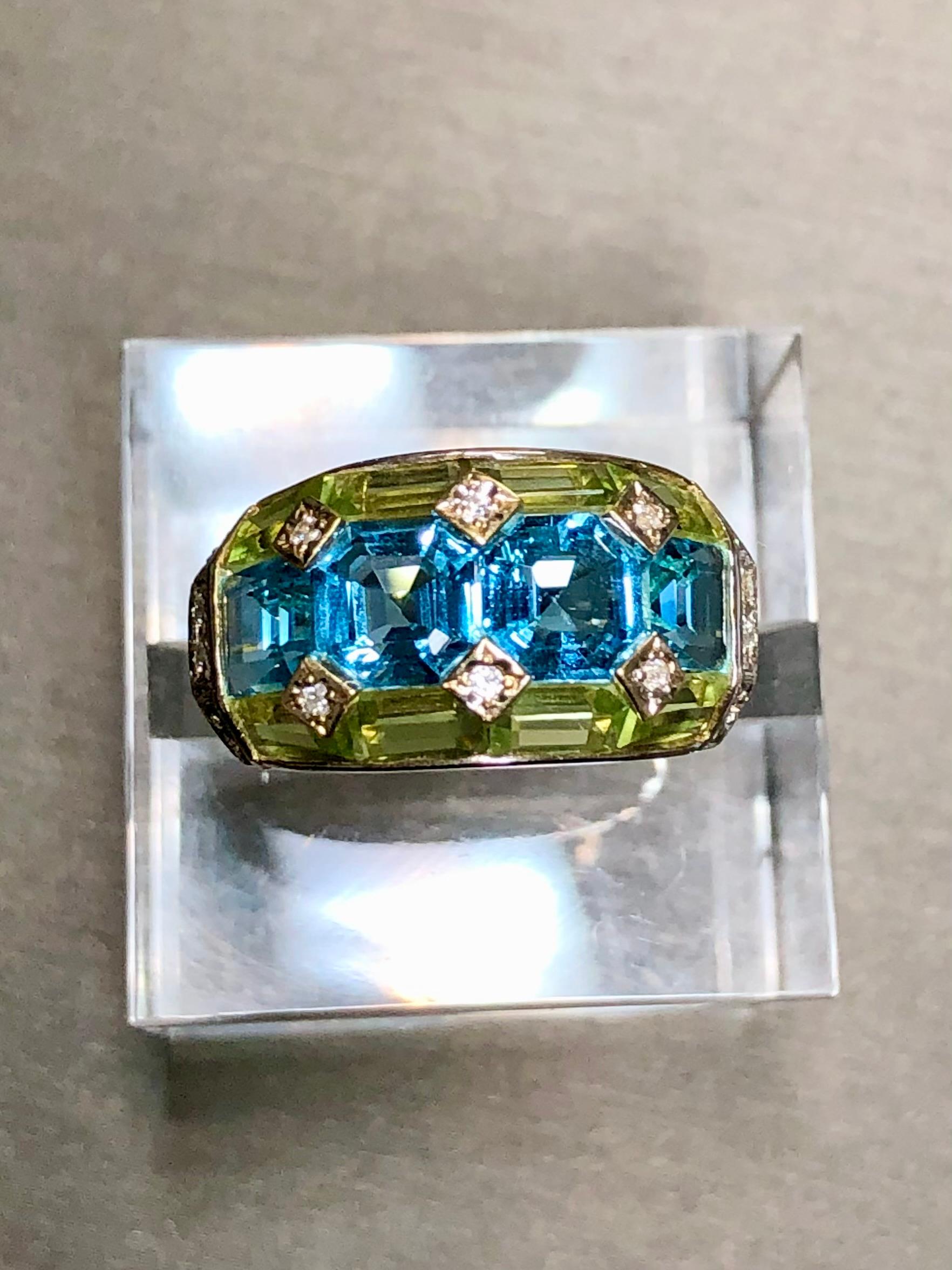 A beautifully made ring done in 18K yellow gold that has been set with 3.35cttw in blue topaz, 2.46cttw, 2.46cttw in green peridot and .09cttw in H-I color Si1-2 clarity diamonds… such a color combination! All weights are stamped inside of the
