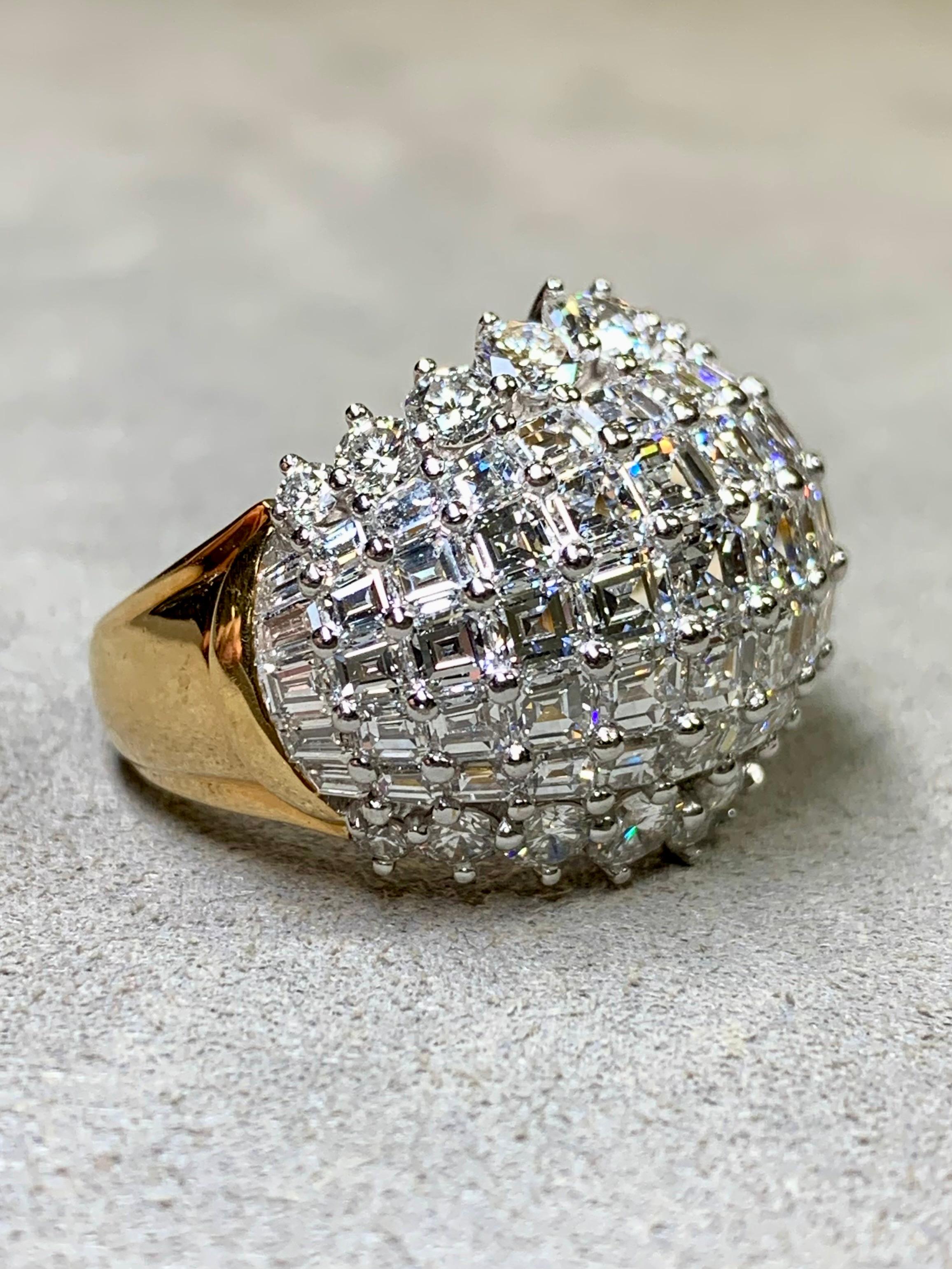 
A spectacular bombé style cocktail ring by Oscar Heyman hand done in 18K yellow gold and platinum and set with approximately 11ctw in F-G color Vs1+ clarity tapered, straight and square baguettes as well as round diamonds. All stones have been set