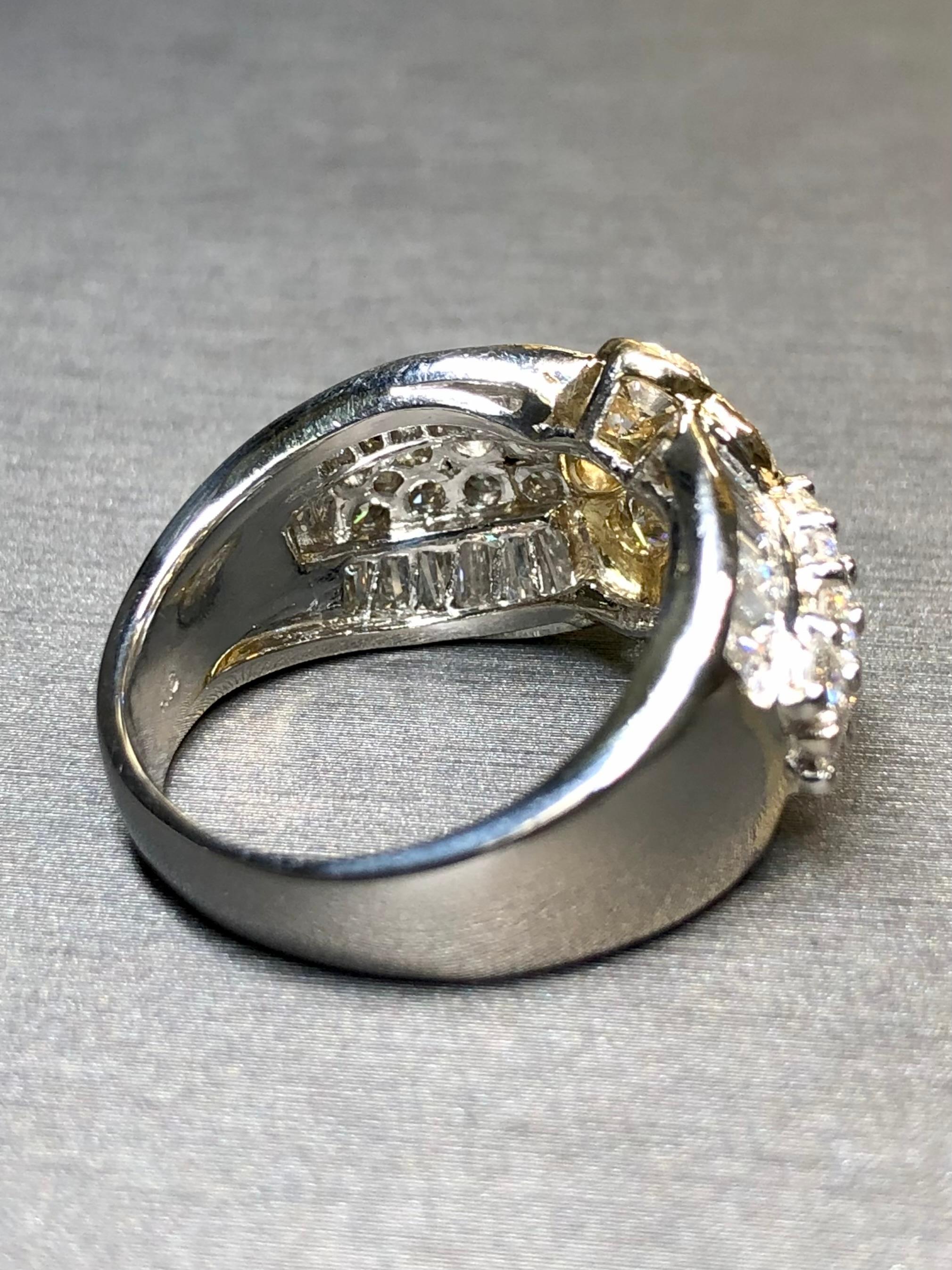 A classic and well made cluster ring done in platinum and 18K yellow gold and set with larger sized round and baguette diamonds up to .15ct each totaling approximately 3.95cttw. Stones are G-H in color and Vs1-2 in