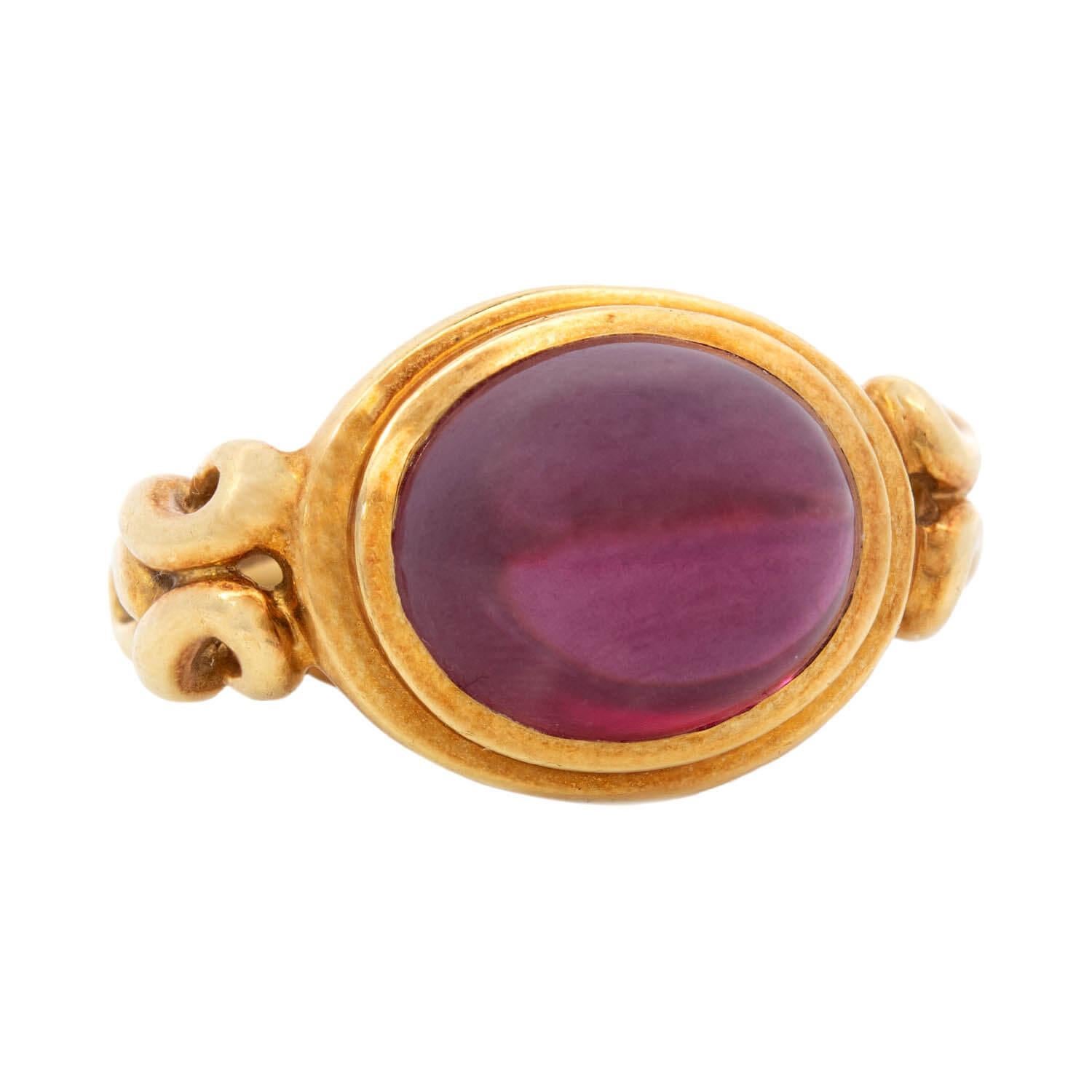 A fantastic Estate rhodolite garnet ring! This 18kt yellow gold piece is bold in size and shape and features a striking rhodolite garnet cabochon at its center. The incredible stone displays a natural reddish-purple color with excellent clarity. A