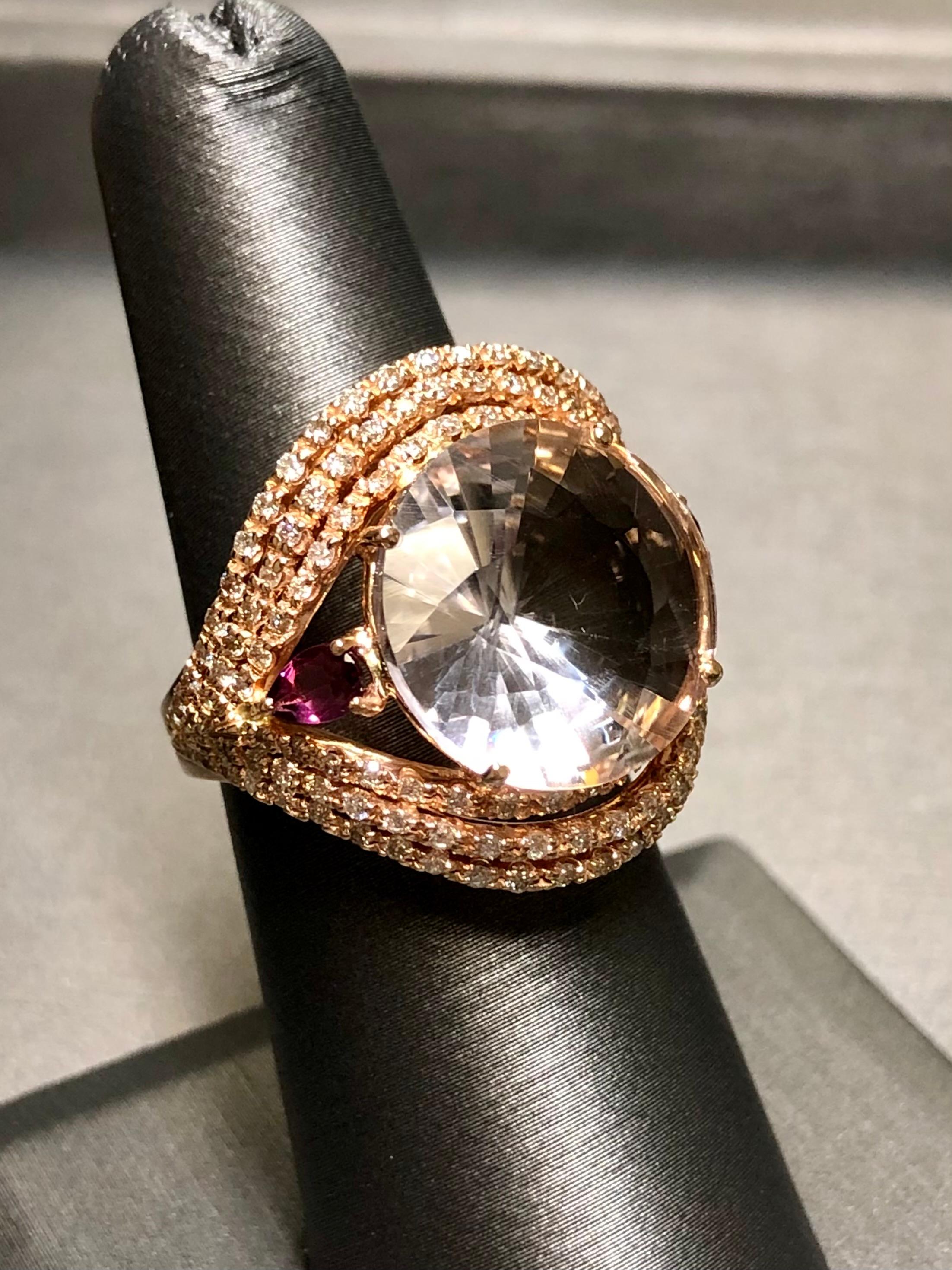 
A bold and beautiful cocktail ring done in 18K rose gold centered by an approximately 9.70ct pale rose quartz flanked on either side by natural pink tourmaline pear shapes averaging 1cttw together. Surrounding all of that wonderful color is