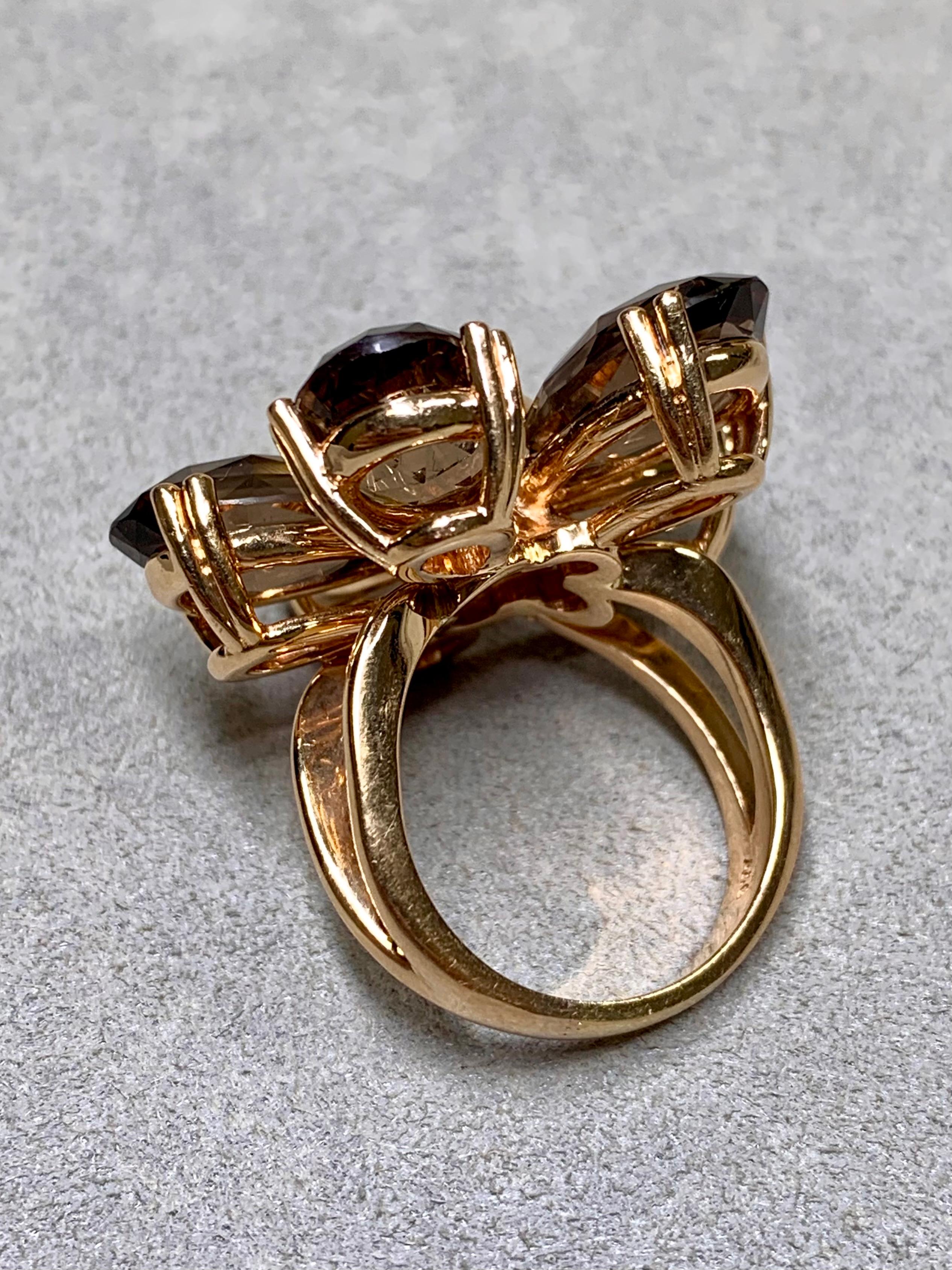 Une impressionnante bague de cocktail florale en or rose 18 carats, conçue avec une précision sculpturale et un équilibre remarquable. Chaque pétale est composé d'un quartz fumé taille fantaisie magnifiquement facetté, totalisant environ 25 carats,