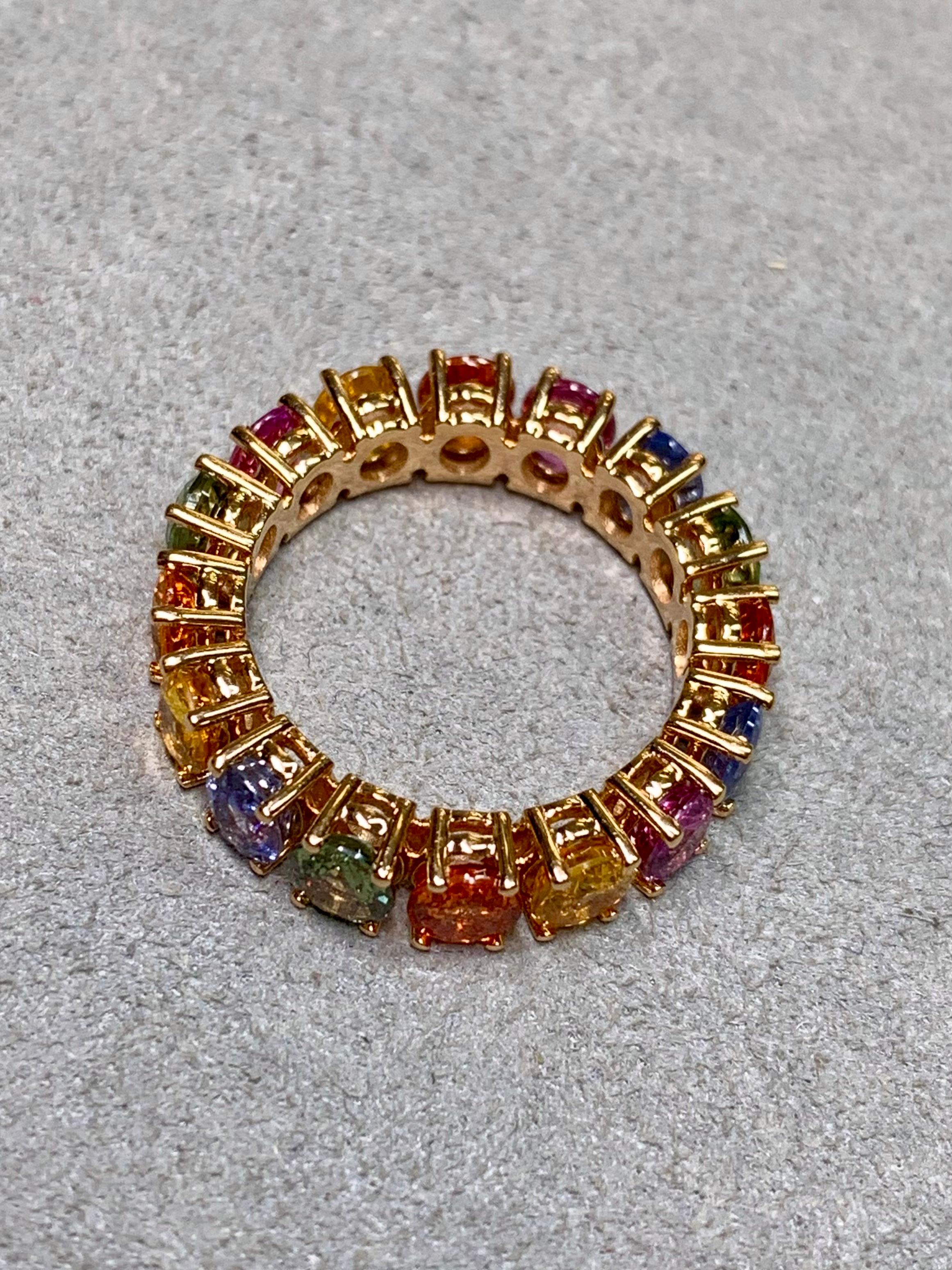 Una vibrante e lussuosa fascia per l'eternità realizzata in oro rosa 18 carati, con un cerchio completo di zaffiri naturali in un abbagliante spettro di colori. Ogni zaffiro dal taglio ovale irradia una brillantezza eccezionale, creando un continuo