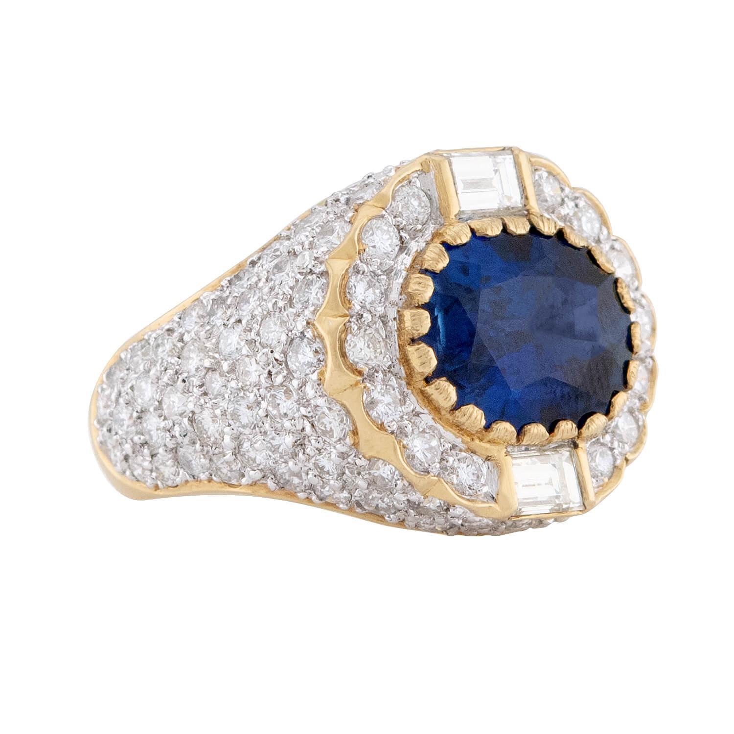 Ein spektakulärer Cocktailring mit Saphiren und Diamanten! Dieser wunderschöne Ring ist aus leuchtendem Gelbgold gefertigt und trägt in der Mitte einen 5,25-karätigen Saphir im Ovalschliff. Der Saphir ist wunderschön facettiert, hat einen tiefen,