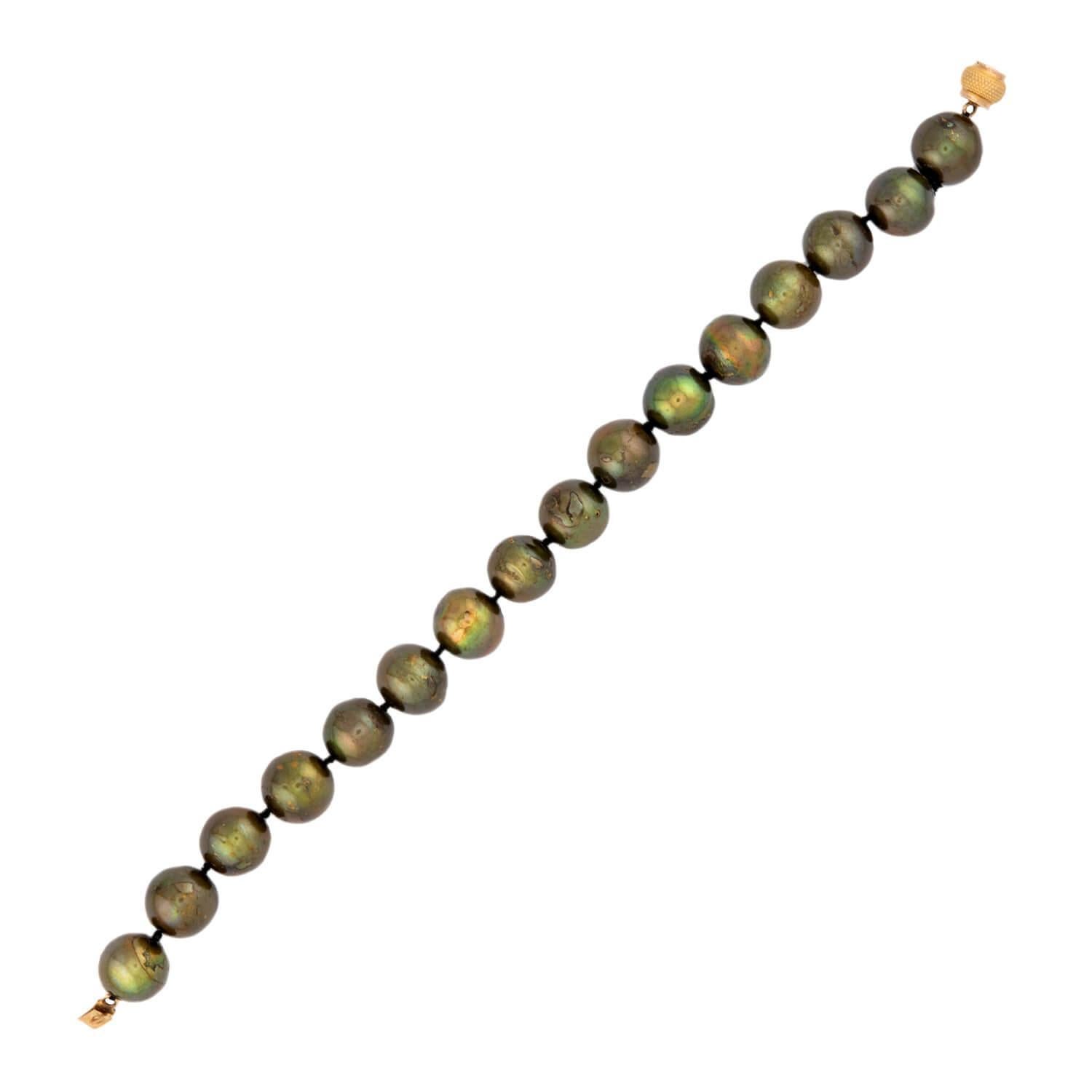 Un bracciale di perle dalla bellezza classica! Realizzato in oro giallo 18 carati, questo bracciale è composto da 16 perle di Tahiti, annodate singolarmente e infilate in un cordoncino nero. Le perle da 12 mm mostrano una lucentezza verde-viola