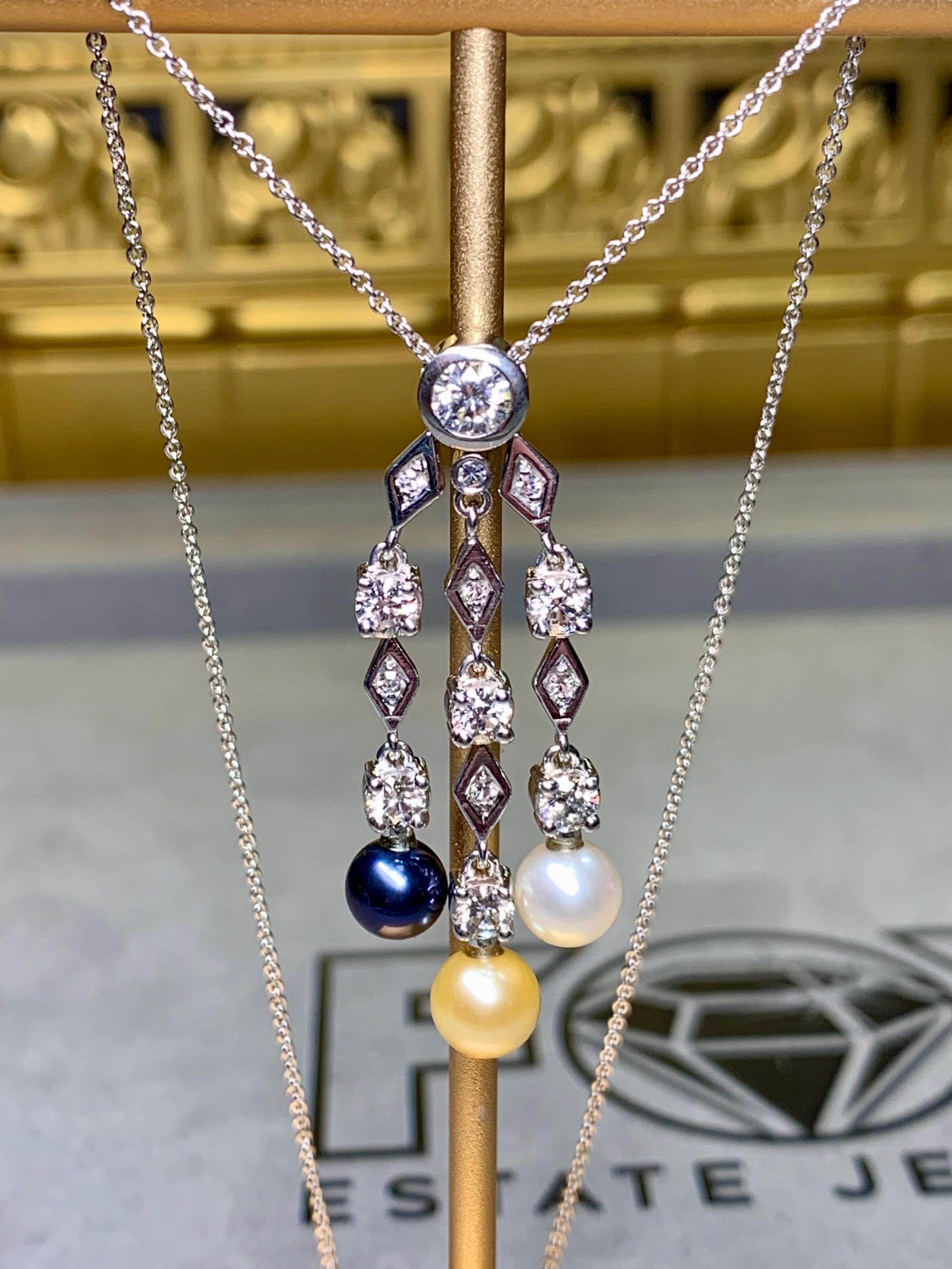 Eine wunderschöne und elegante Halskette mit drei Anhängern aus 18 Karat Weißgold, die an einer feinen Kette aus 14 Karat Weißgold hängt. Dieses raffinierte Design zeichnet sich durch ein Trio leuchtender Perlen in Grau-, Weiß- und Goldtönen aus,