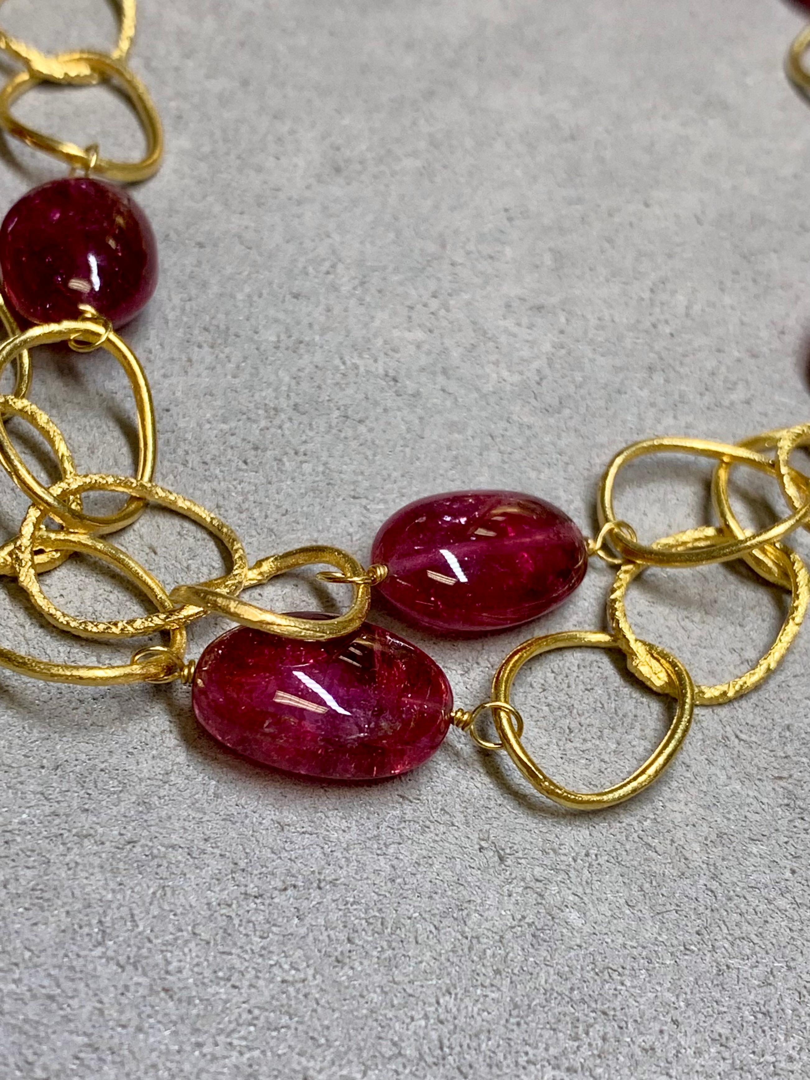 An impressive opera length necklace crafted in deep 18K yellow gold and finished with a lovely hand-texturing that can be seen throughout. Separating each section are large, tumbled rubellite tourmaline weighing between 5ct and 12ct each. A