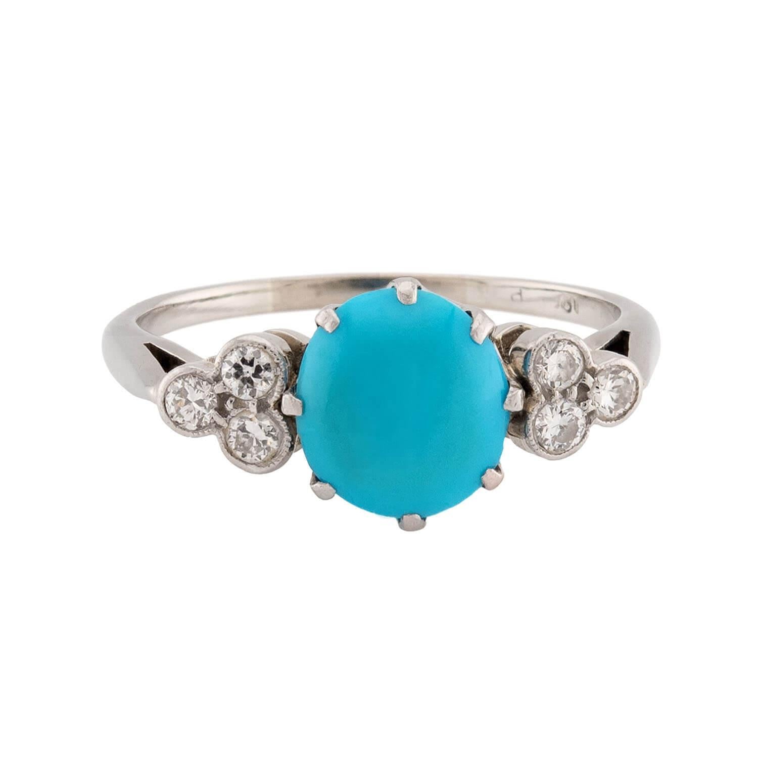 Uno splendido anello con turchese e diamanti! Realizzato in oro bianco 18 carati, questo anello presenta un cabochon circolare centrale di turchese, racchiuso in una montatura a più punte. Il cabochon mostra una tonalità verde-blu incredibilmente
