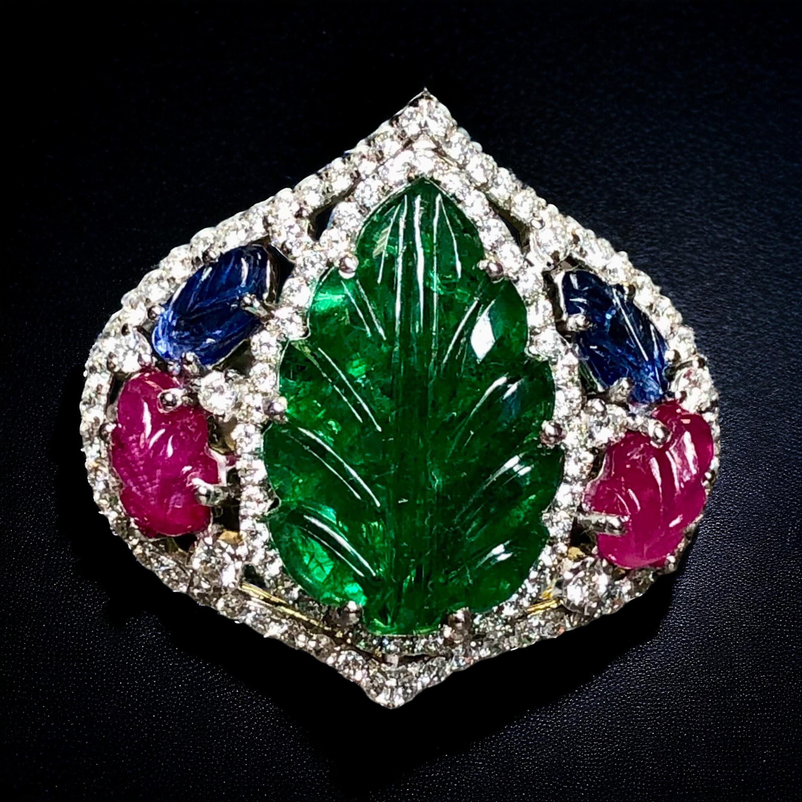 A fabulous Deco-style “tutti frutti” cocktail Ring crafted in 18K white gold and centered by a 6.53ct (known weight) natural carved emerald exhibiting absolutely stunning color and very pleasant clarity. Flanking the center stone are carved natural