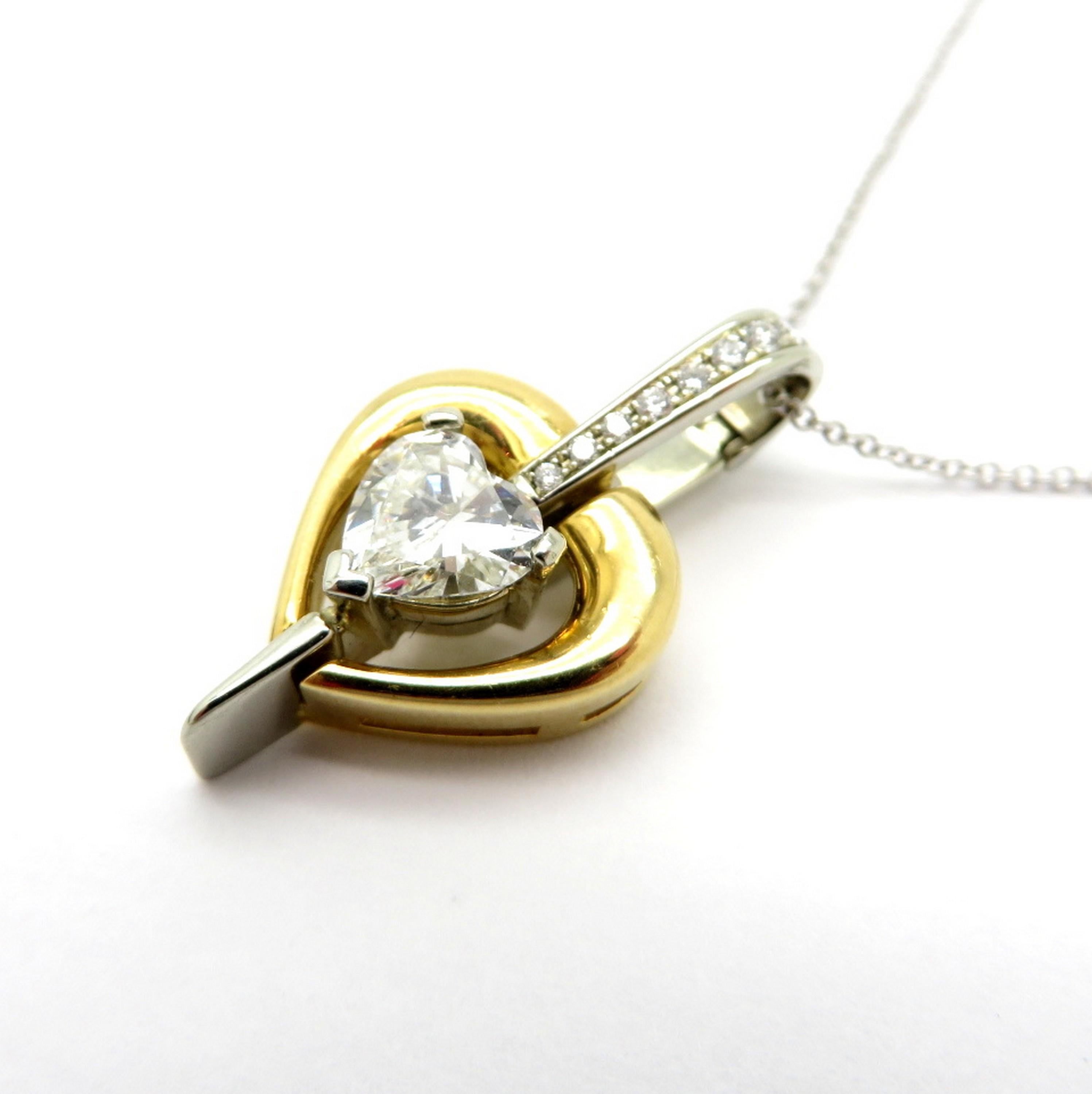 Estate 18K two-tone gold diamond fashion heart shaped pendant necklace. Showcasing one heart shaped diamond, three prong set, weighing approximately 1.00 carat. Diamond grading: color grade: H. Clarity grade: VS1. Accented with nine round brilliant