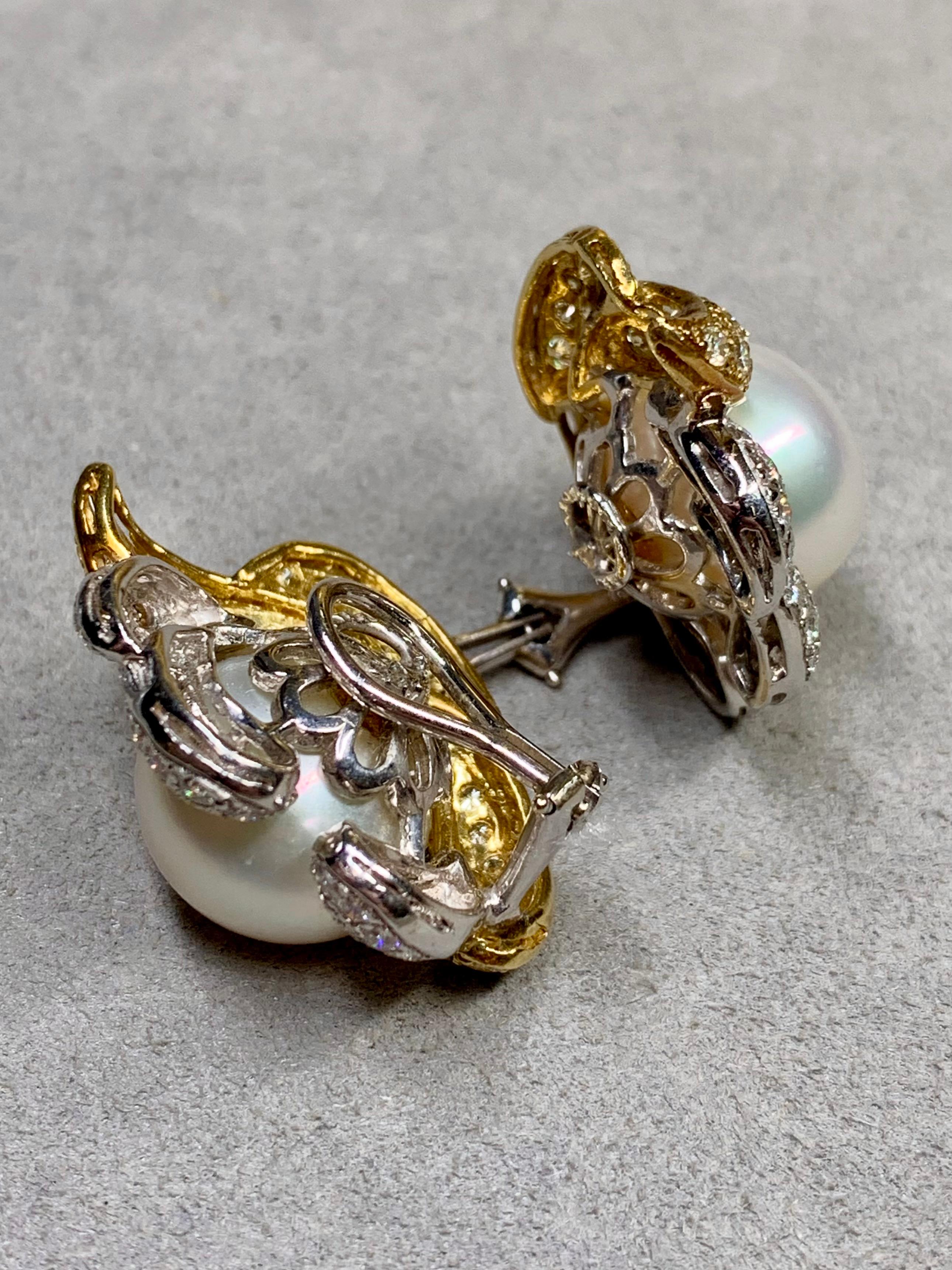 Contemporary ear clips done in 18K white and yellow gold centered with 14.80mm & 14.90mm cream colored south sea pearls surrounded by approximately 4.25ctw in round cut F-G color Vs1-2 clarity diamonds as well as light fancy yellow Vs1-2 clarity