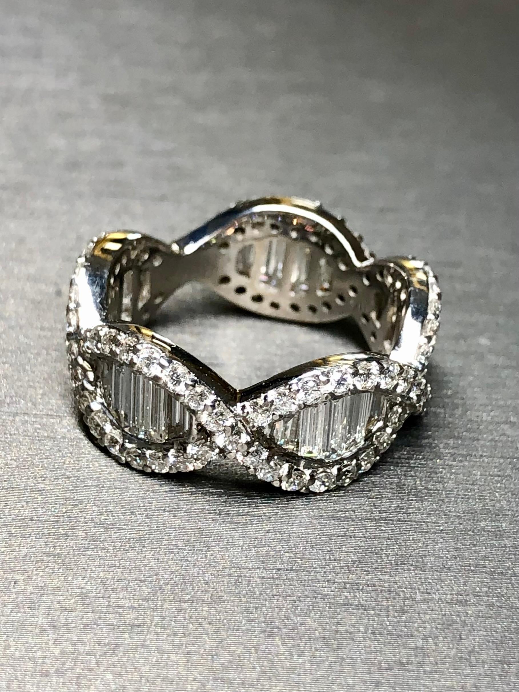 A very beautifully done eternity band crafted in 18K white gold and both channel and flush set with approximately 4.25cttw in straight baguette and round diamonds all averaging G-H in color and Vs1-2 clarity. The central largest baguettes are about
