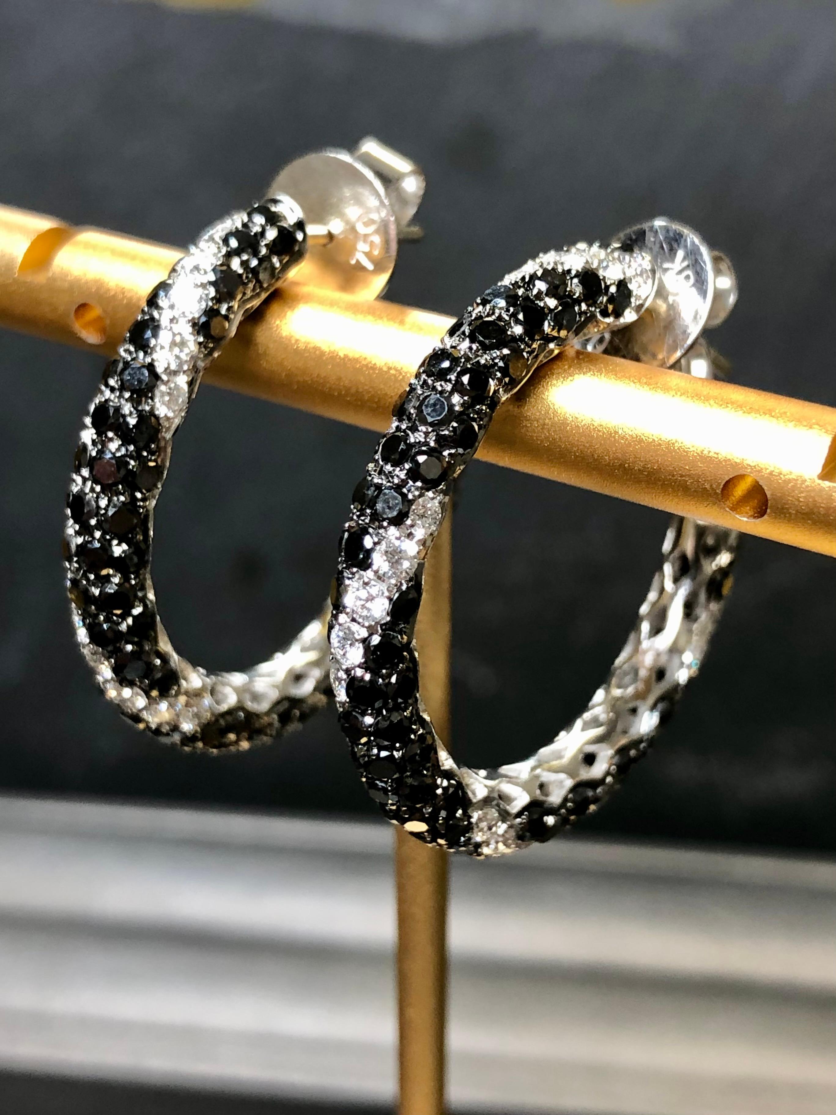 Contemporary earrings done in 18K white gold set with 5.43cttw (stamped weight) in black and white natural diamonds (1.20cttw in white/4.23cttw in black). White diamonds range G-I in color and Vs2-Si1 in clarity. These earrings come with oversized