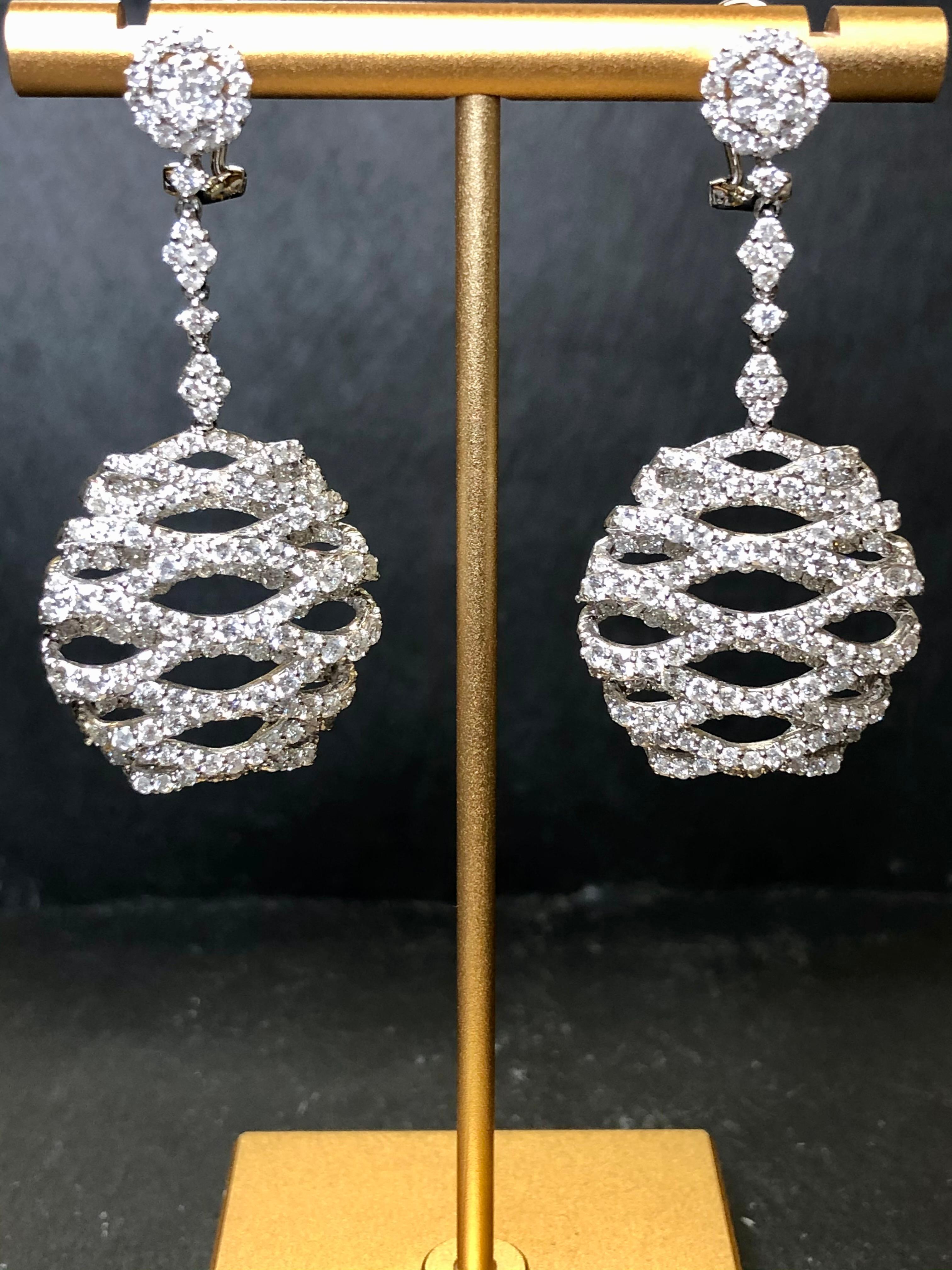 An incredible pair of statement earrings done in 18K white gold and set with approximately 8cttw in G-J color Vs2-I1 clarity round diamonds. Super bright with a three dimensional honeycomb-style design, they sparkly from every angle. Absolutely