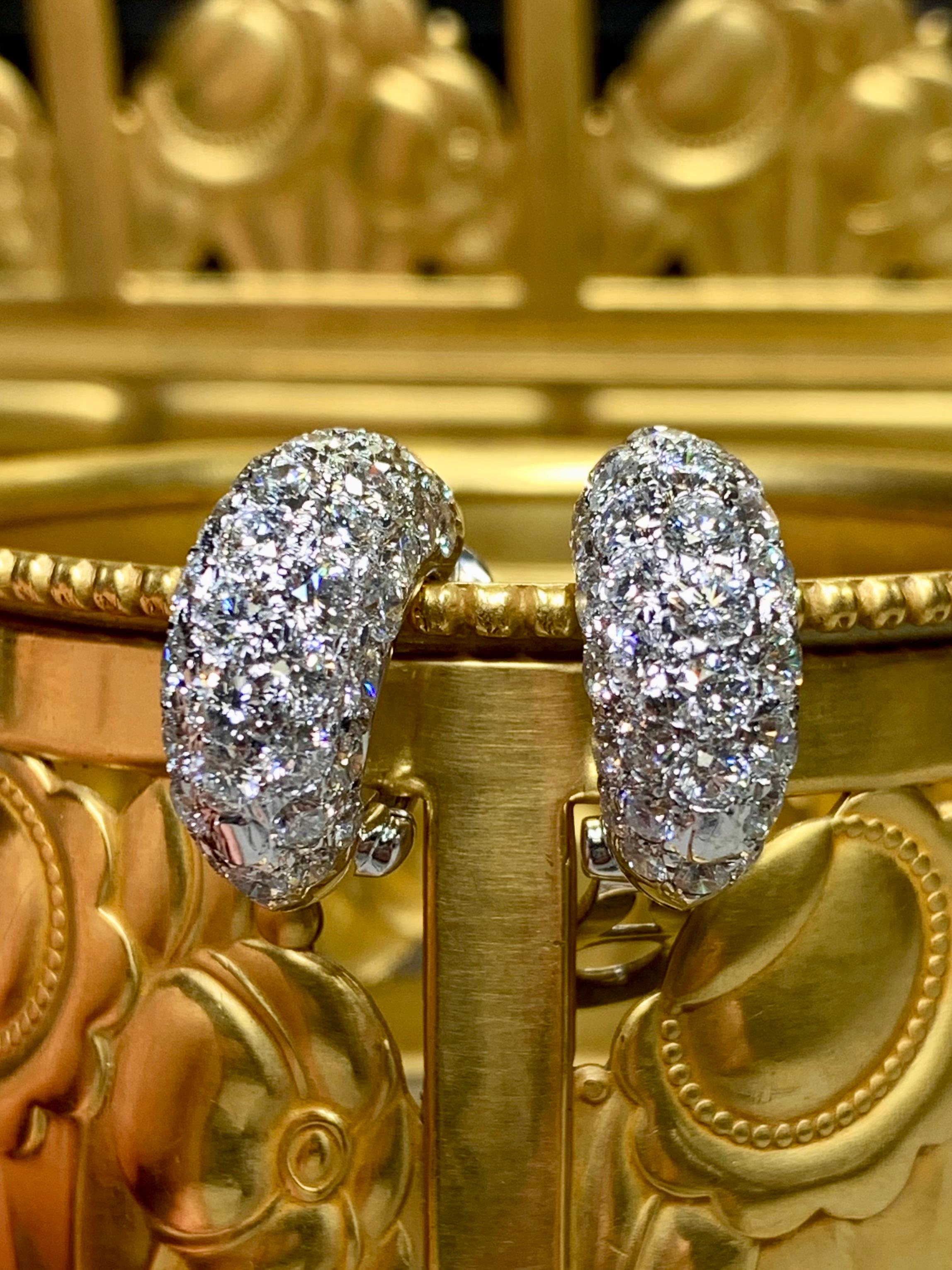 A timeless pair of diamond huggies done in 18K white gold and set with approximately 9.50ctw in beautifully set and well matched round diamonds averaging G-H in color and Vs1-Si1 in clarity. These earrings have posts with omega