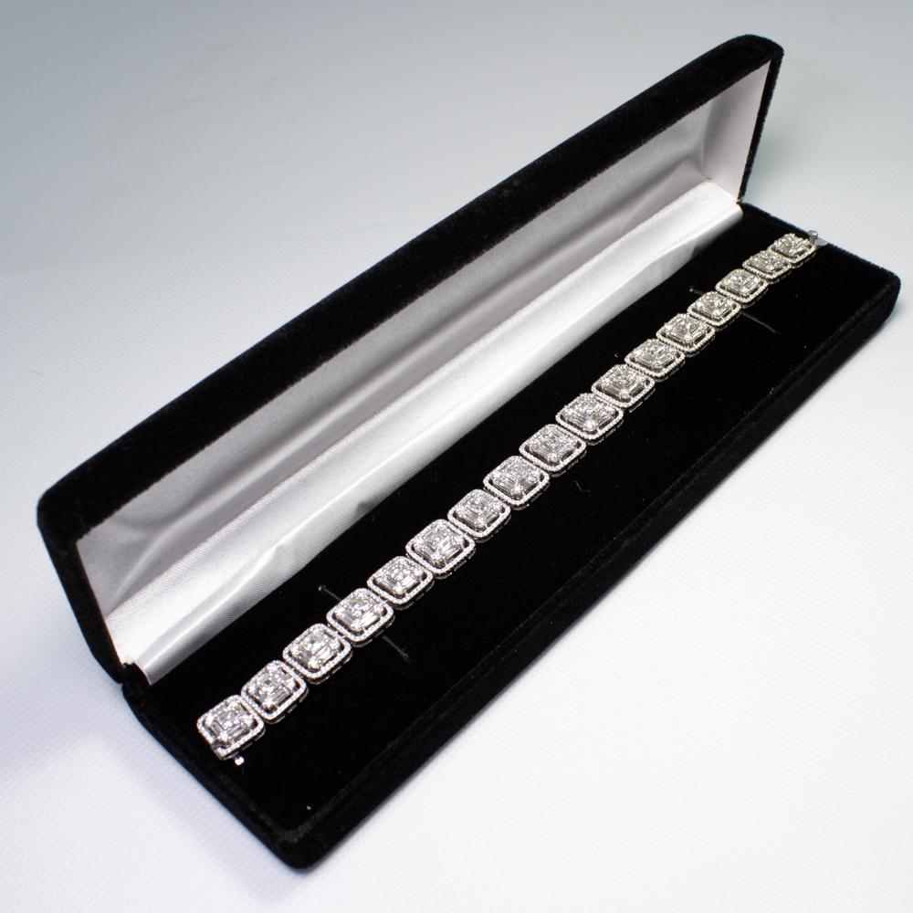 Estate 18K white gold emerald cut, round, and baguette diamond halo tennis bracelet. Featuring numerous emerald cut, baguette shaped and round brilliant cut diamonds with various measurements weighing a combined total of approximately 18.75 carats.