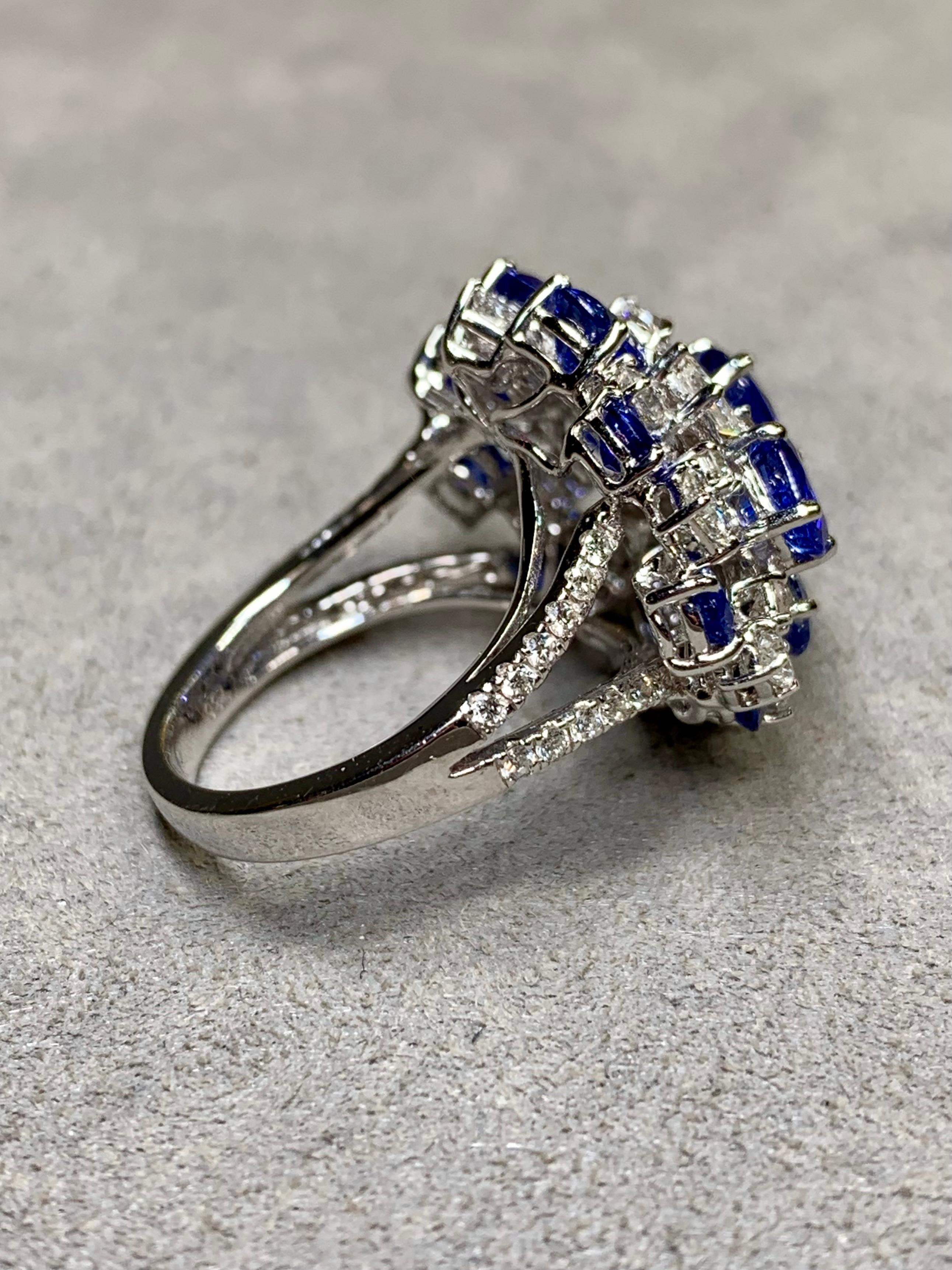 A fabulous cocktail ring done in 18K white gold and set with approximately 3ctw in G-H color and Vs1-Si1 clarity prong set round, princess, trilliant, emerald and marquise shaped diamonds. It also has approximately 7ctw in royal blue, oval cut
