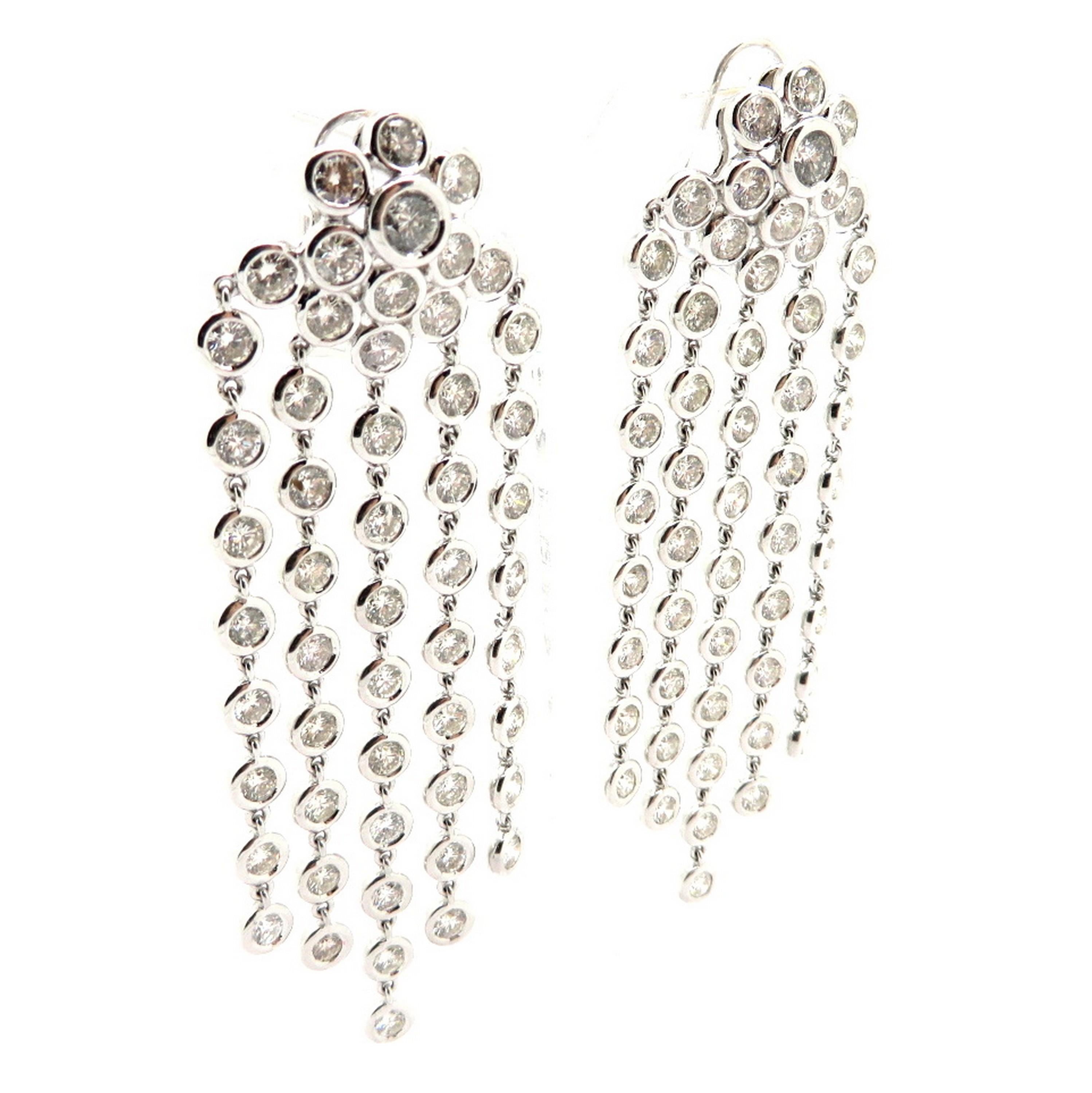 Estate 18K white gold floral chandelier round diamond dangle earrings. Showcasing 104 bezel set round brilliant cut diamonds weighing a combined total of approximately 16.00 carats. Diamond grading: color grade: G – H. Clarity grade: SI1 – SI2. The