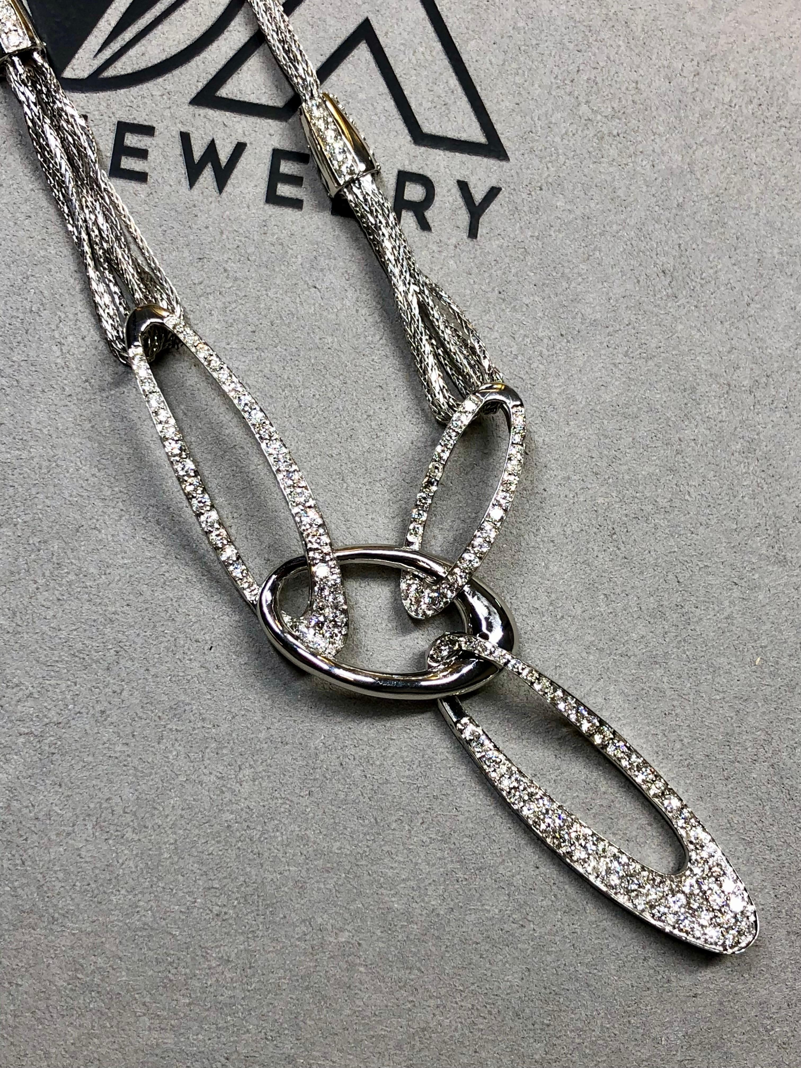 
A gorgeous, contemporary necklace crafted in 18K white gold and pavé set with an approximately 4.35ctw in H-J color Si1-i1 clarity round diamonds. It has been done in a bold, multi-chain link design to be worn in an almost offset manner. An