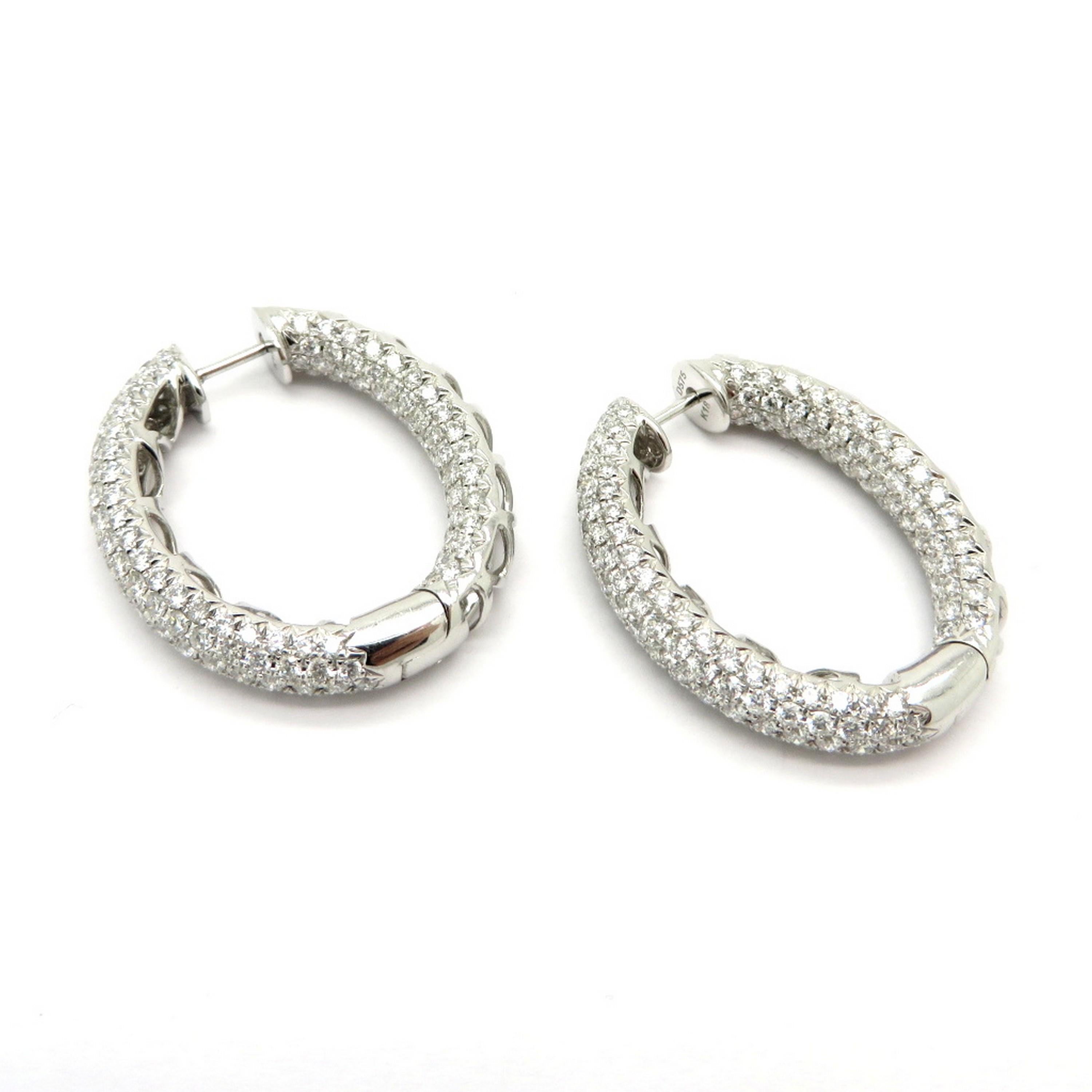 Estate 18K white gold pave oval diamond hoop earrings. Showcasing 346 round brilliant cut pave set diamonds weighing a combined total of approximately 5.75 carats. Diamond grading: color grade: G – H. Clarity grade: VS2 – SI1. The earrings are