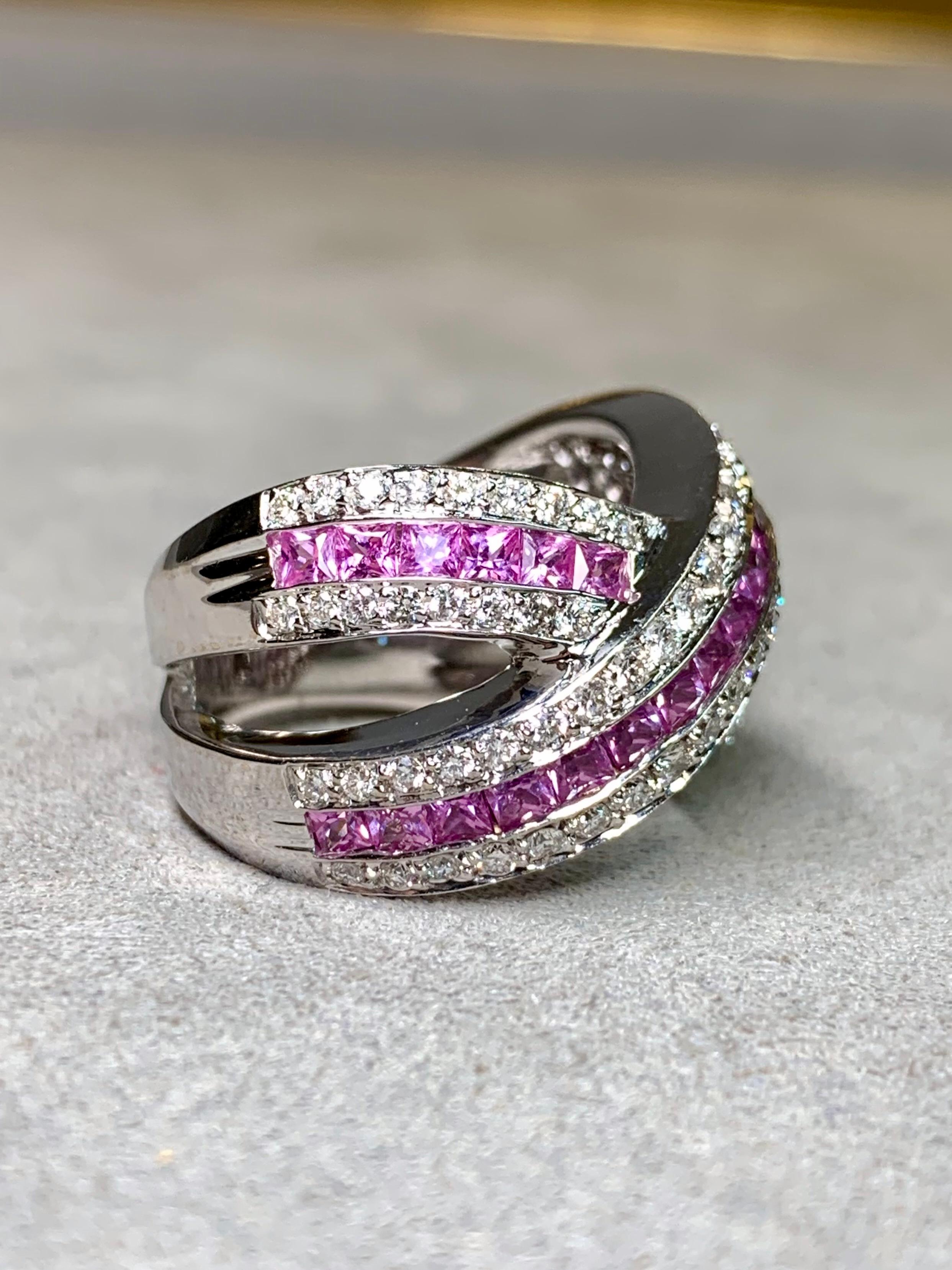 
Une bague de cocktail étonnante et substantielle en or blanc 18 carats, conçue dans un motif croisé audacieux. Les rangées de saphirs roses naturels de taille carrée contrastent magnifiquement avec les diamants ronds étincelants, créant une pièce