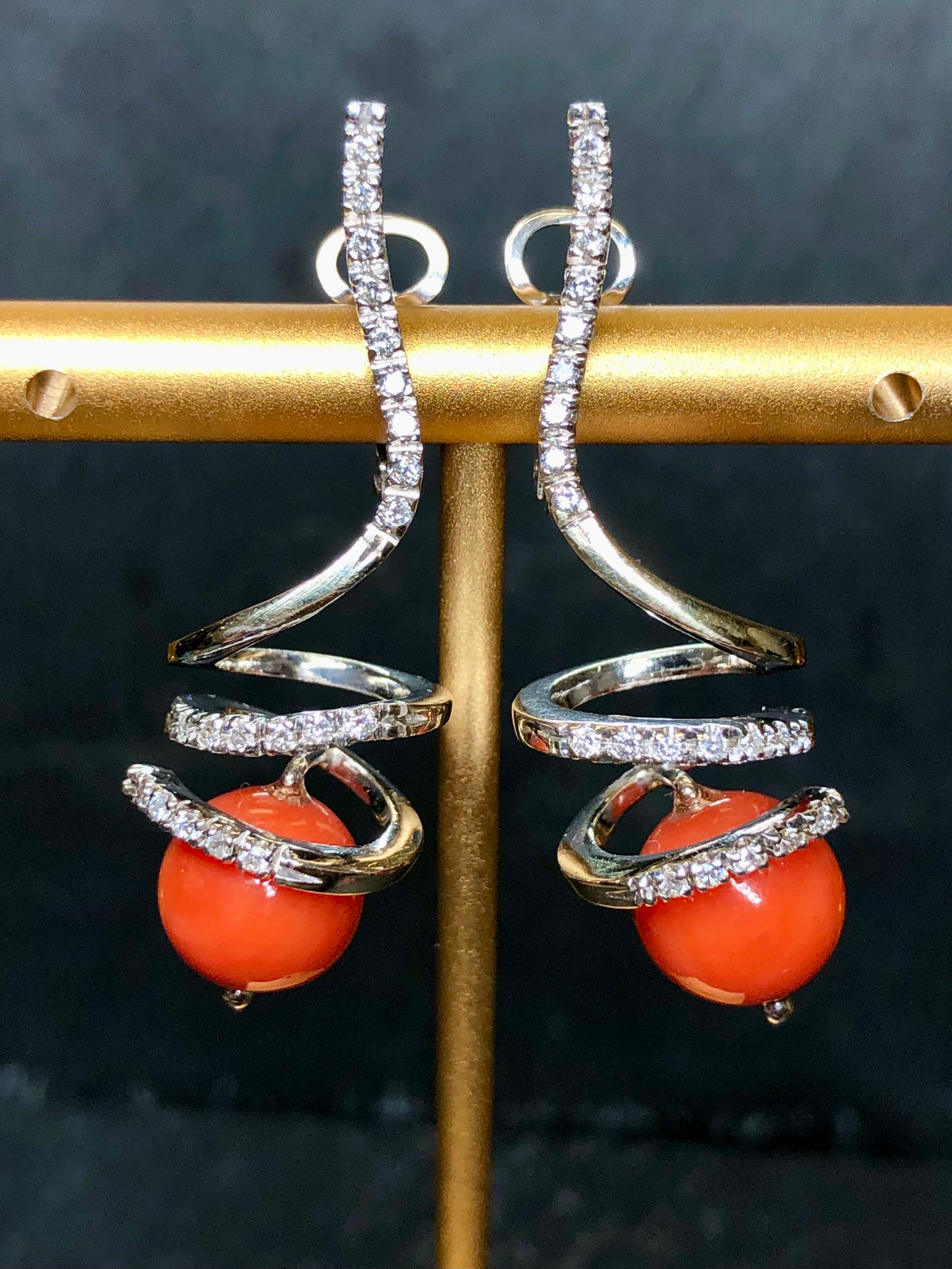 Italian made earrings done in 18K white gold set with approximately .40cttw G-H color Vs1-2 clarity round diamonds and finished with natural red coral beads measuring 9.30mm in diameter. These earrings have posts with omega
