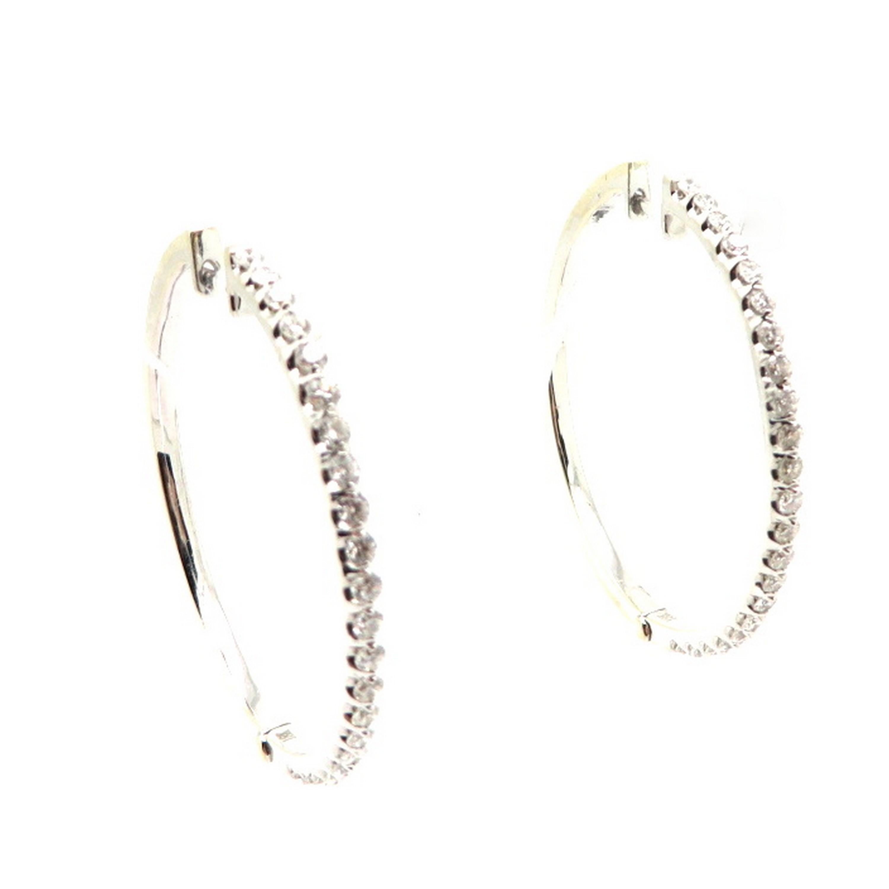 Estate 18K white gold round diamond hoop earrings. Showcasing 44 round brilliant cut prong set diamonds weighing a combined total of approximately 1.19 carats. Diamond grading: color grade: H – I. Clarity grade: SI1. Each earring measures 1-½”