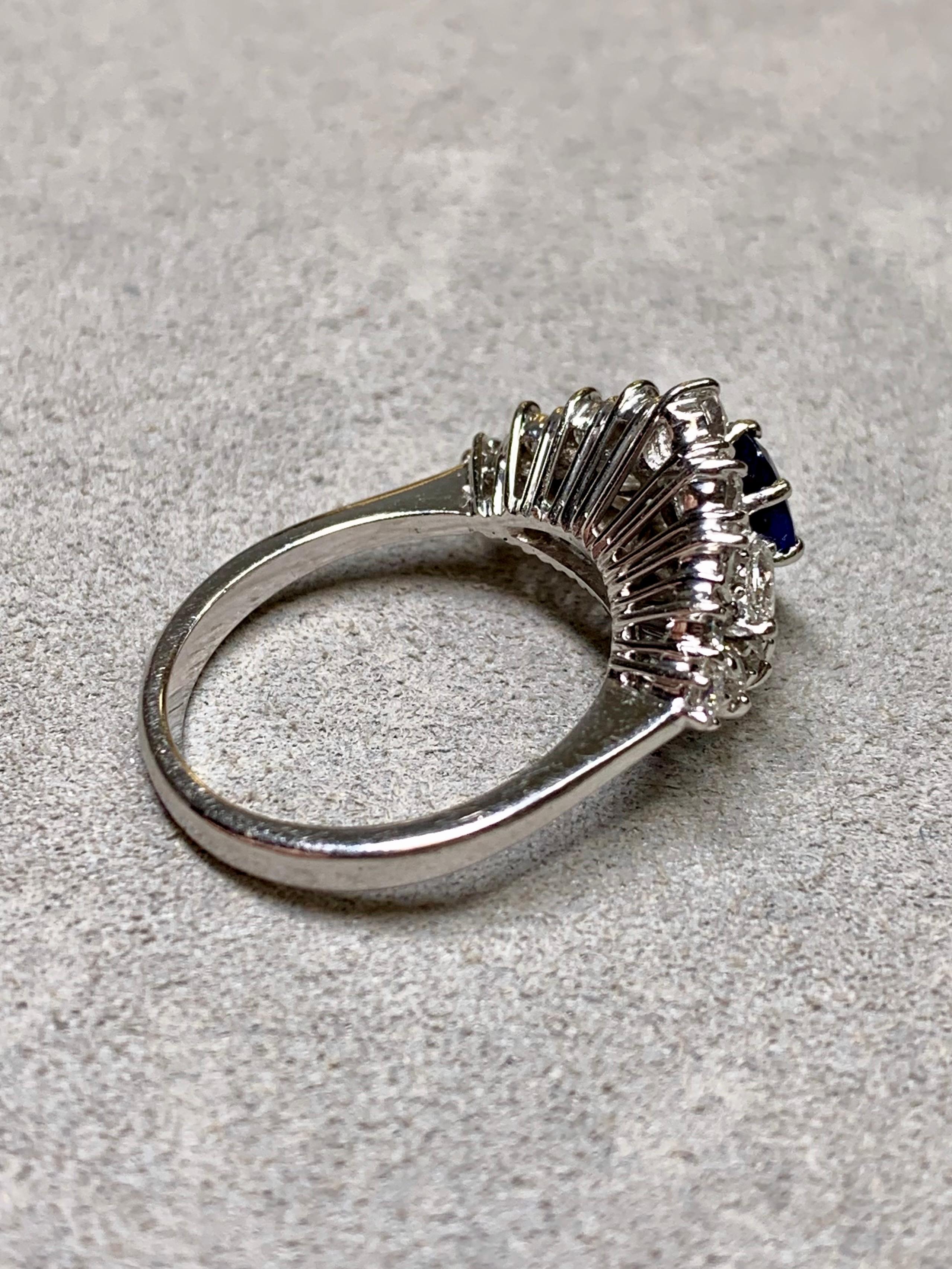 Bague vintage raffinée en or blanc 18 carats, ornée d'un saphir naturel d'un bleu royal profond et richement coloré pesant environ 1,00 carat. Le saphir est entouré d'un élégant arrangement de diamants ronds et de diamants taille marquise,