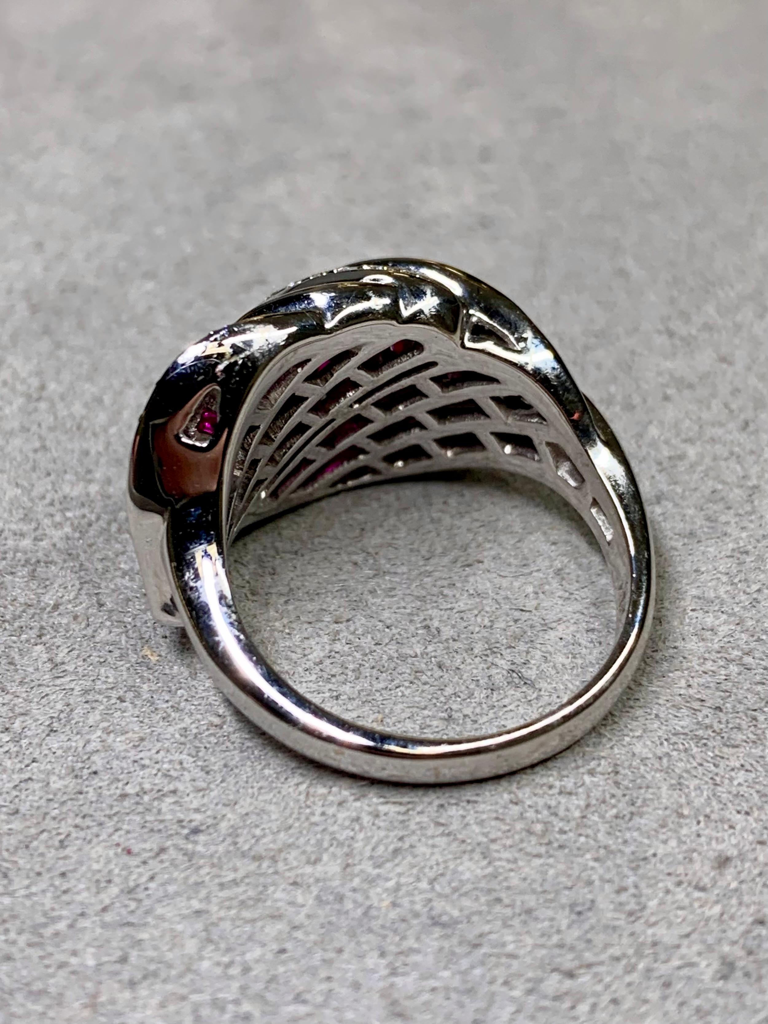 Ein auffälliger Ring aus 18 Karat Weißgold mit einem eleganten Bypass-Blattmotiv. Das Schmuckstück ist mit ca. 1,84 Karat Gesamtgewicht an leuchtend roten Rubinen im Baguetteschliff besetzt, die sorgfältig kalibriert und präzise ausgerichtet sind.