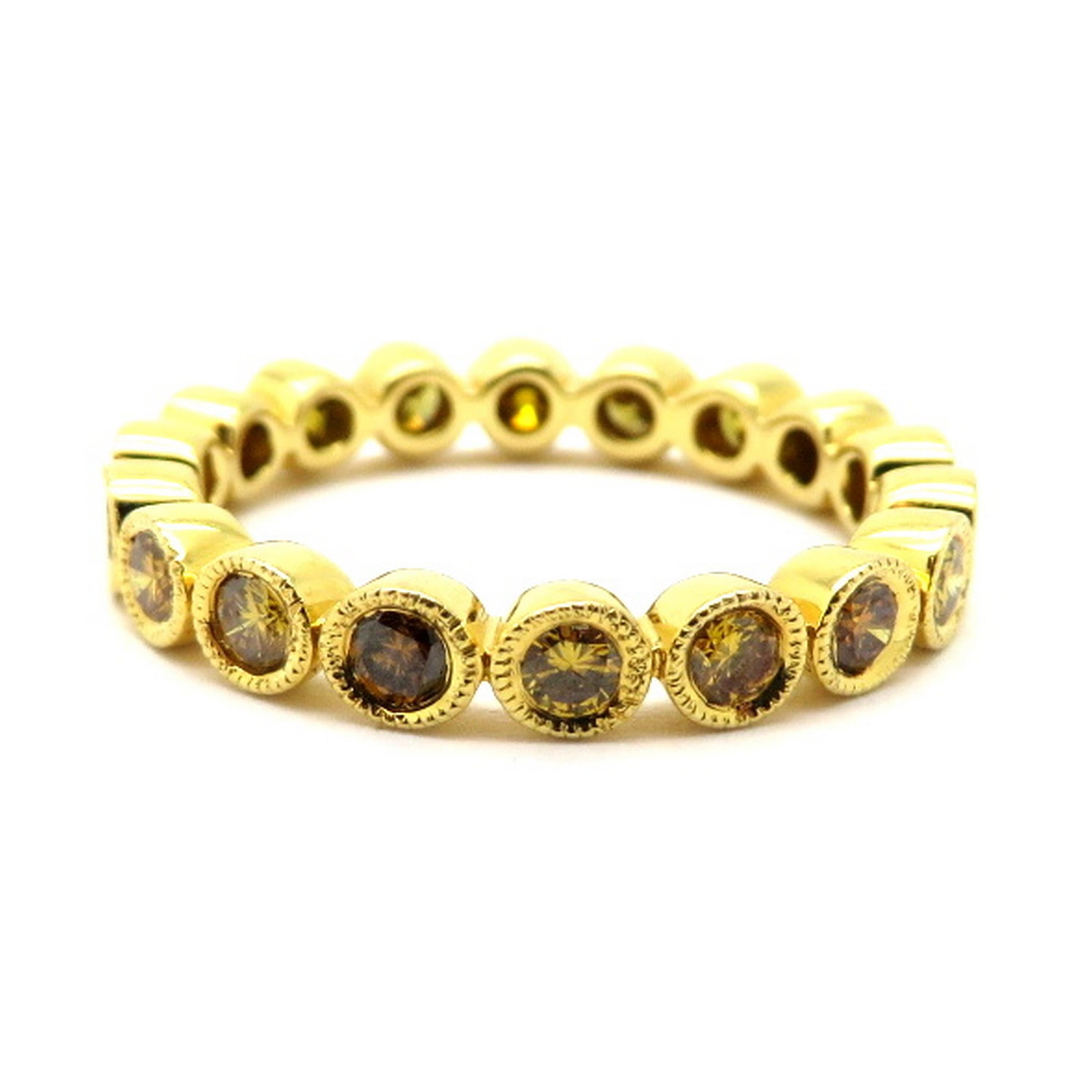 Estate 18K yellow gold fancy yellowish orange round diamond eternity band ring. Showcasing 18 round brilliant cut fancy yellowish orange diamonds weighing a combined total of approximately 0.98 carats. Clarity grade: SI1. The ring is crafted out of