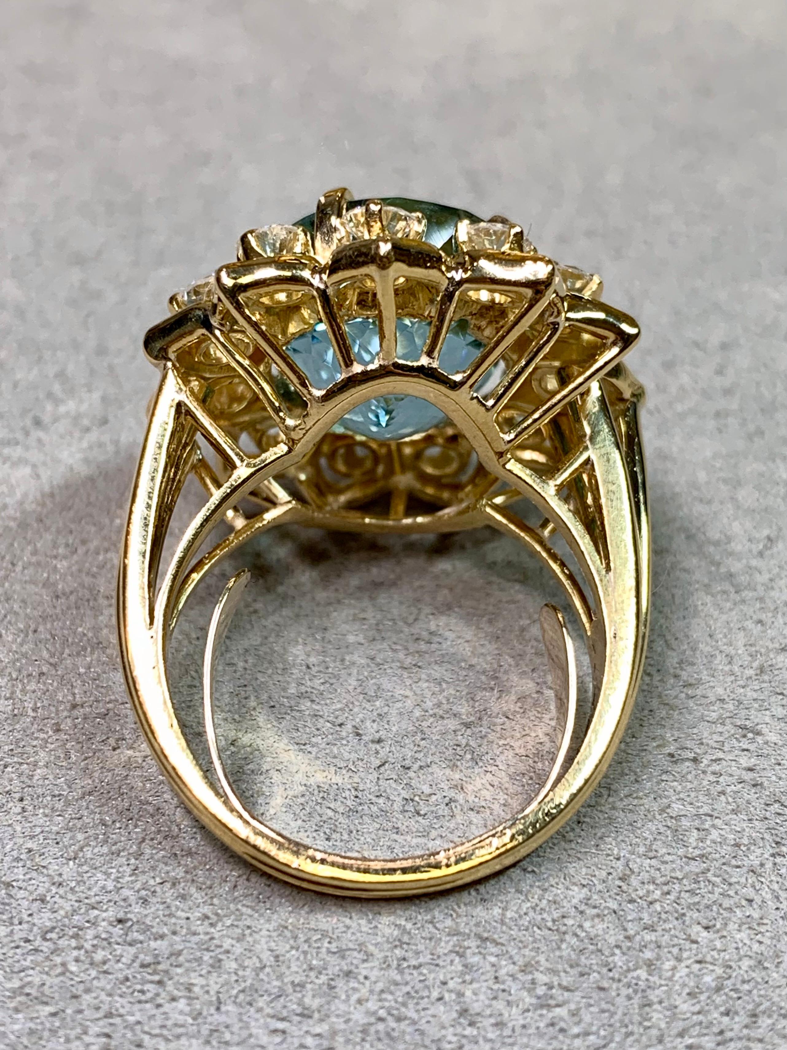 
Une bague de cocktail remarquable et magnifiquement équilibrée, réalisée en or jaune 18 carats, centrée par une aigue-marine naturelle lumineuse d'environ 10 carats. La gemme présente une taille mixte légèrement ovale avec une excellente brillance