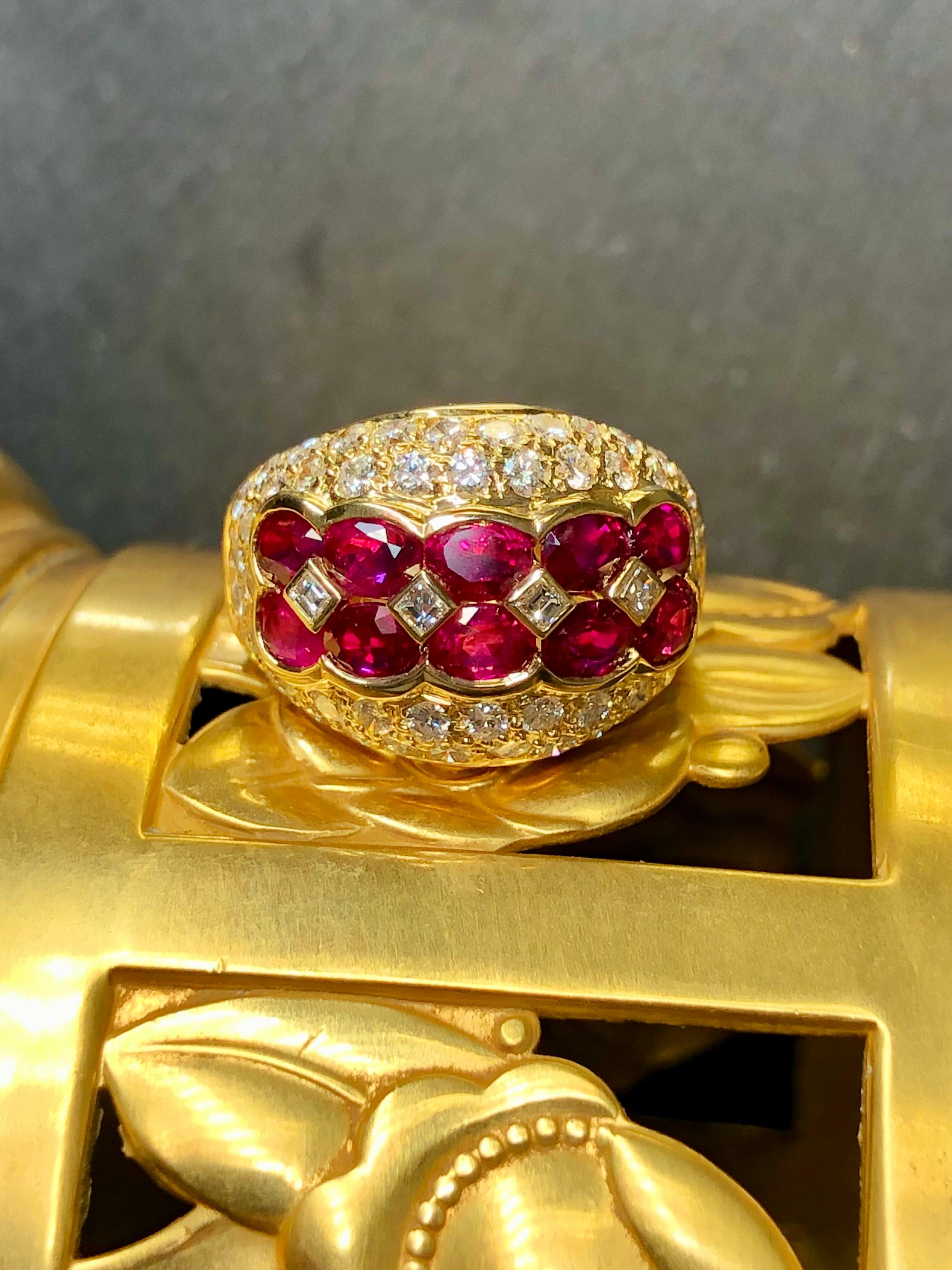 An impressive cocktail ring that just sparkles! It is done in 18K yellow gold and centered by 10 larger oval natural bright red rubies separated by bezel set square baguette diamonds. Surrounding the rubies are pave round diamonds averaging G-I