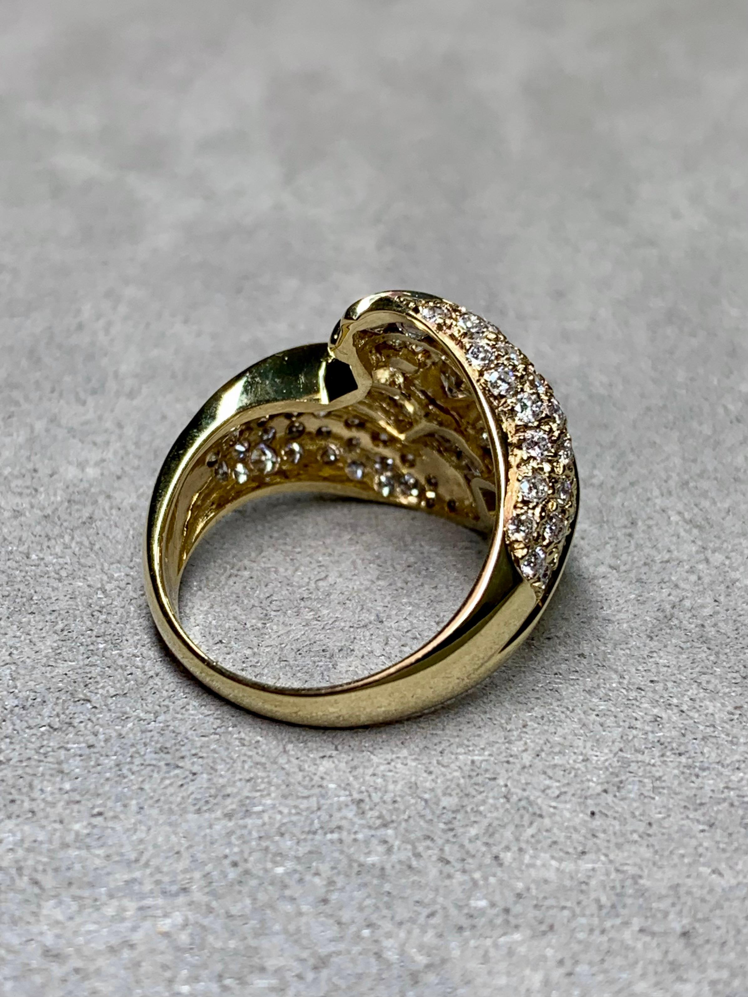A lovely bypass ring done in 18K yellow gold and centered by an approximately .45ct princess cut diamond being H-I in color and Si1 in clarity. Channel and pave set throughout the gallery of the ring is another 3ctw in baguette and round diamonds