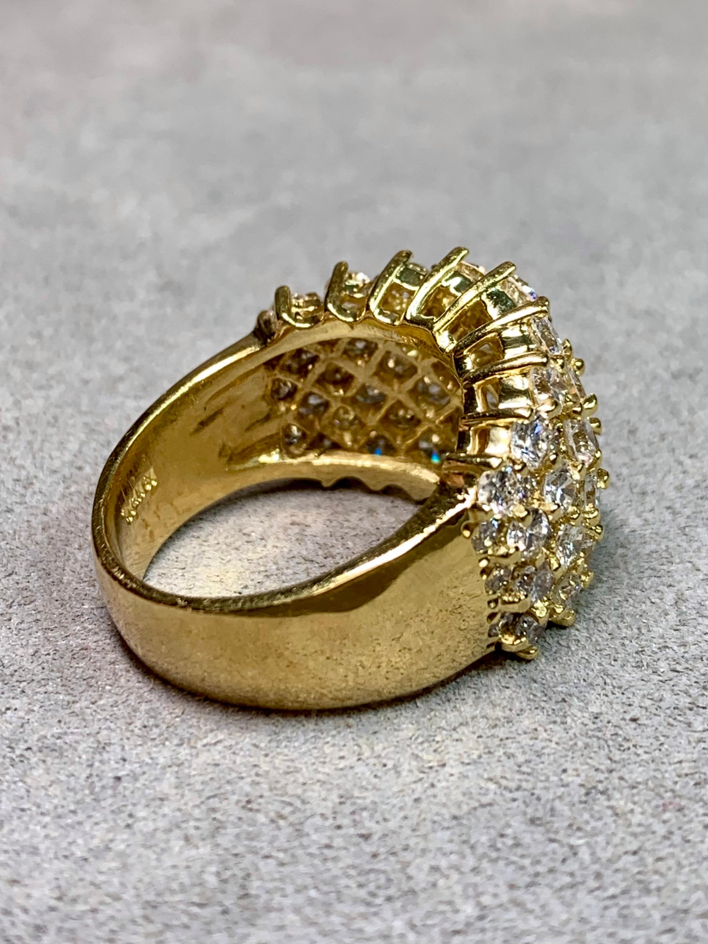 
Remarquable bague de cocktail à large bande, magistralement exécutée en or jaune 18 carats et entièrement incrustée de diamants ronds de taille brillant totalisant environ 7,00 carats. Le design présente des diamants primaires plus grands, chacun