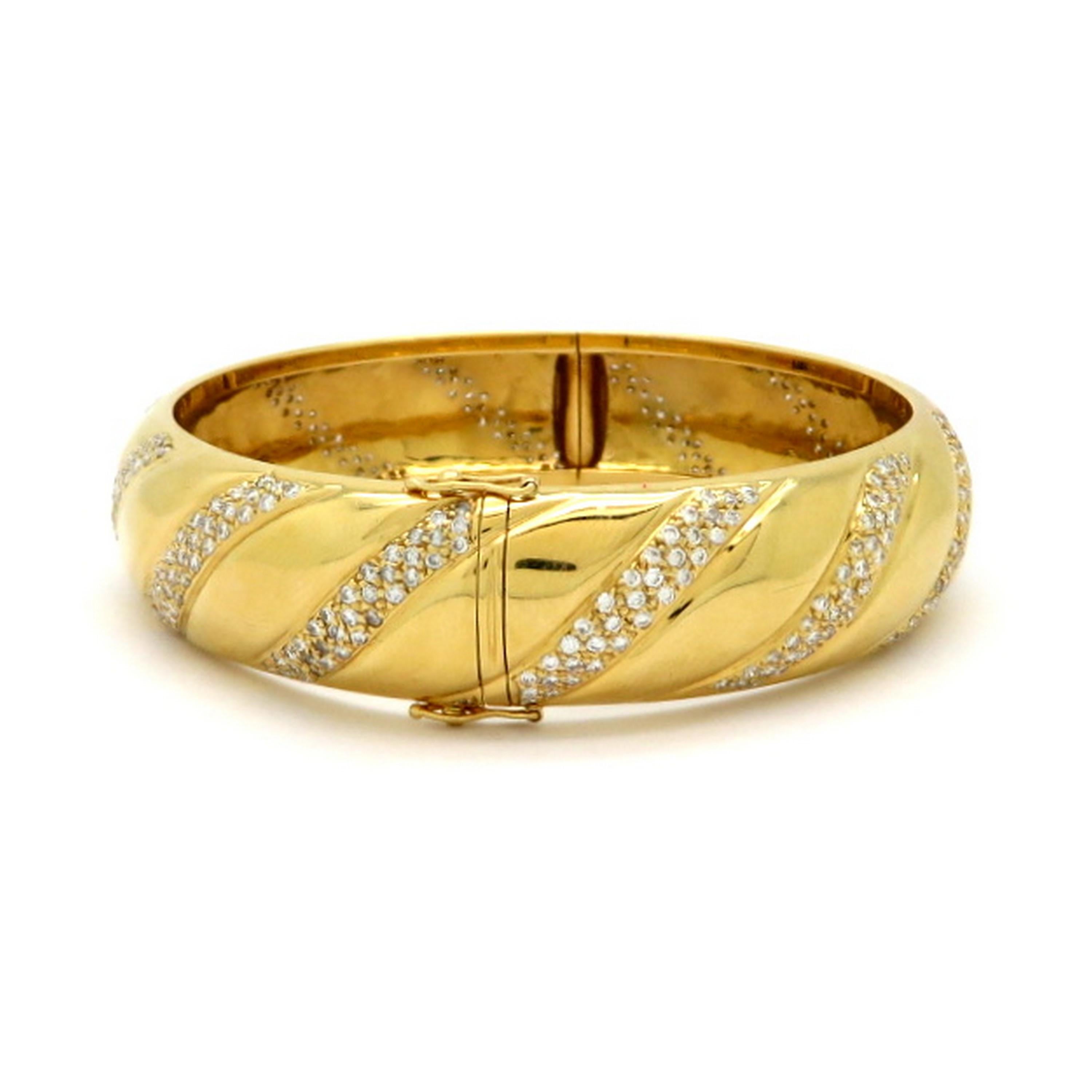 Estate 18K yellow gold round diamond twist swirl bangle fashion bracelet. Accented with 430 bead set round brilliant cut diamonds weighing a combined total of approximately 2.25 carats. Diamond grading: color grade: G – H. Clarity grade: VS1 – VS2.