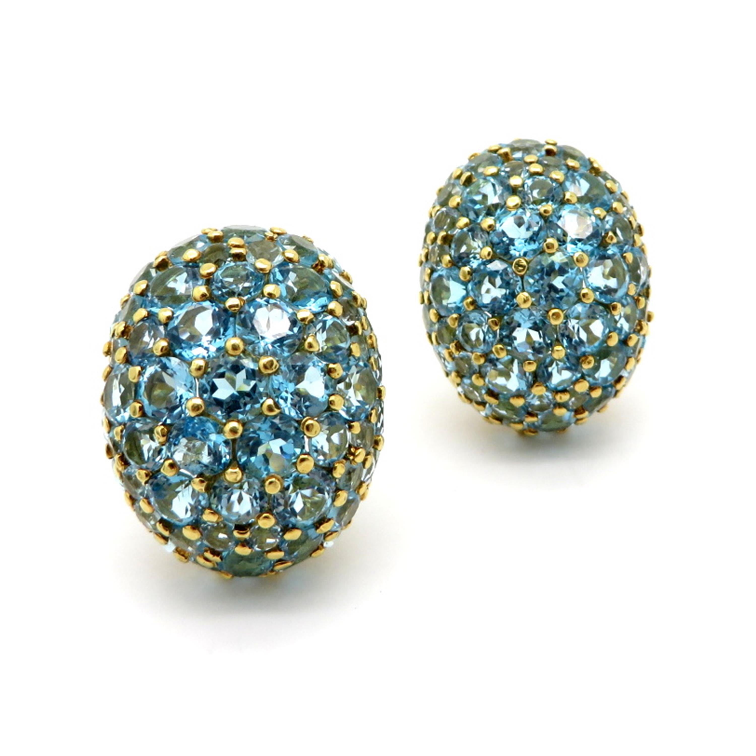 Estate 18K yellow gold sky blue topaz oval cluster 18K yellow gold clip on earrings. Featuring numerous round brilliant cut sky blue topaz gemstones, in a pave design weighing approximately 10.00 carats total. The earrings are secured with clip on